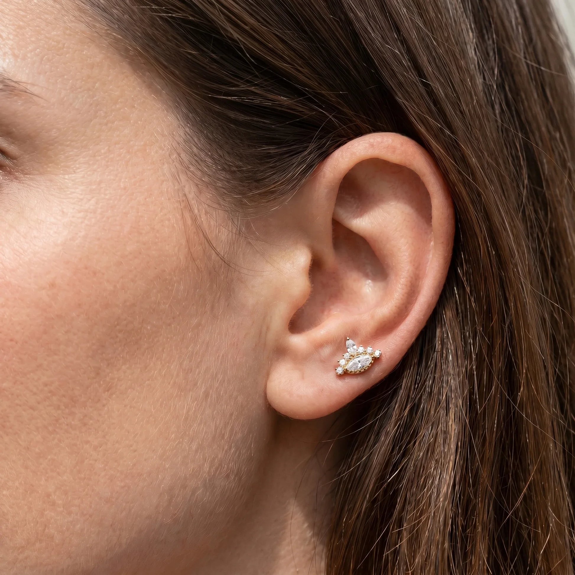 Gold evil eye stud worn in a standard piercing.