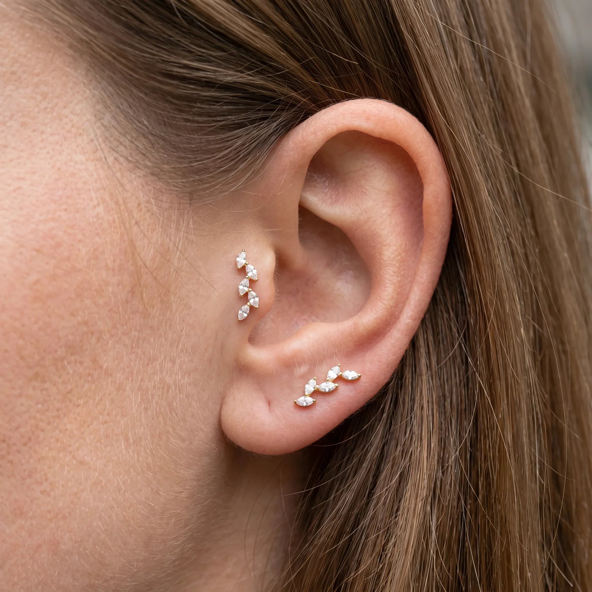 Gold marquise cluster stud styled in an and piercing setup.