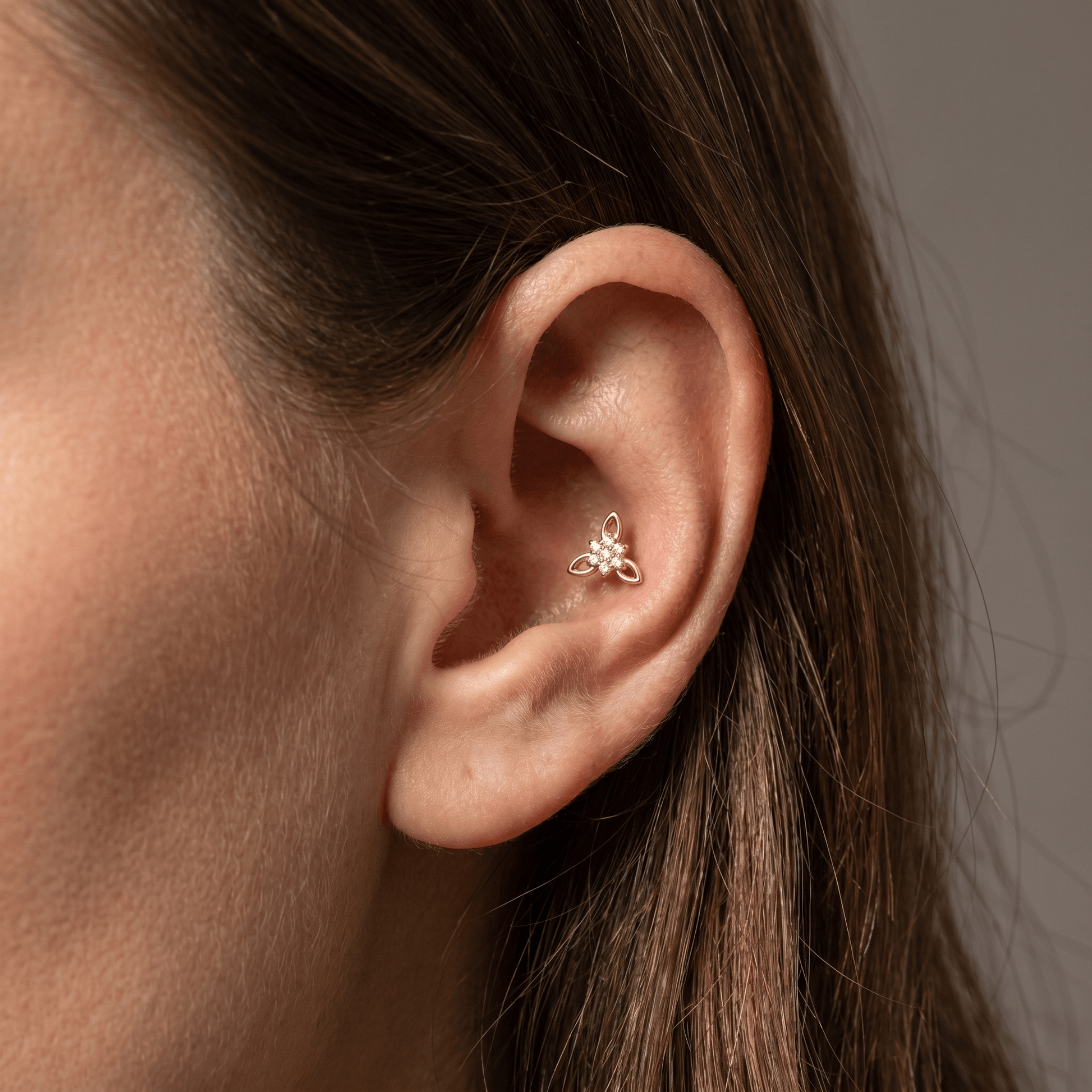 Gold titanium CZ flower cluster piercing stud worn beautifully in a female