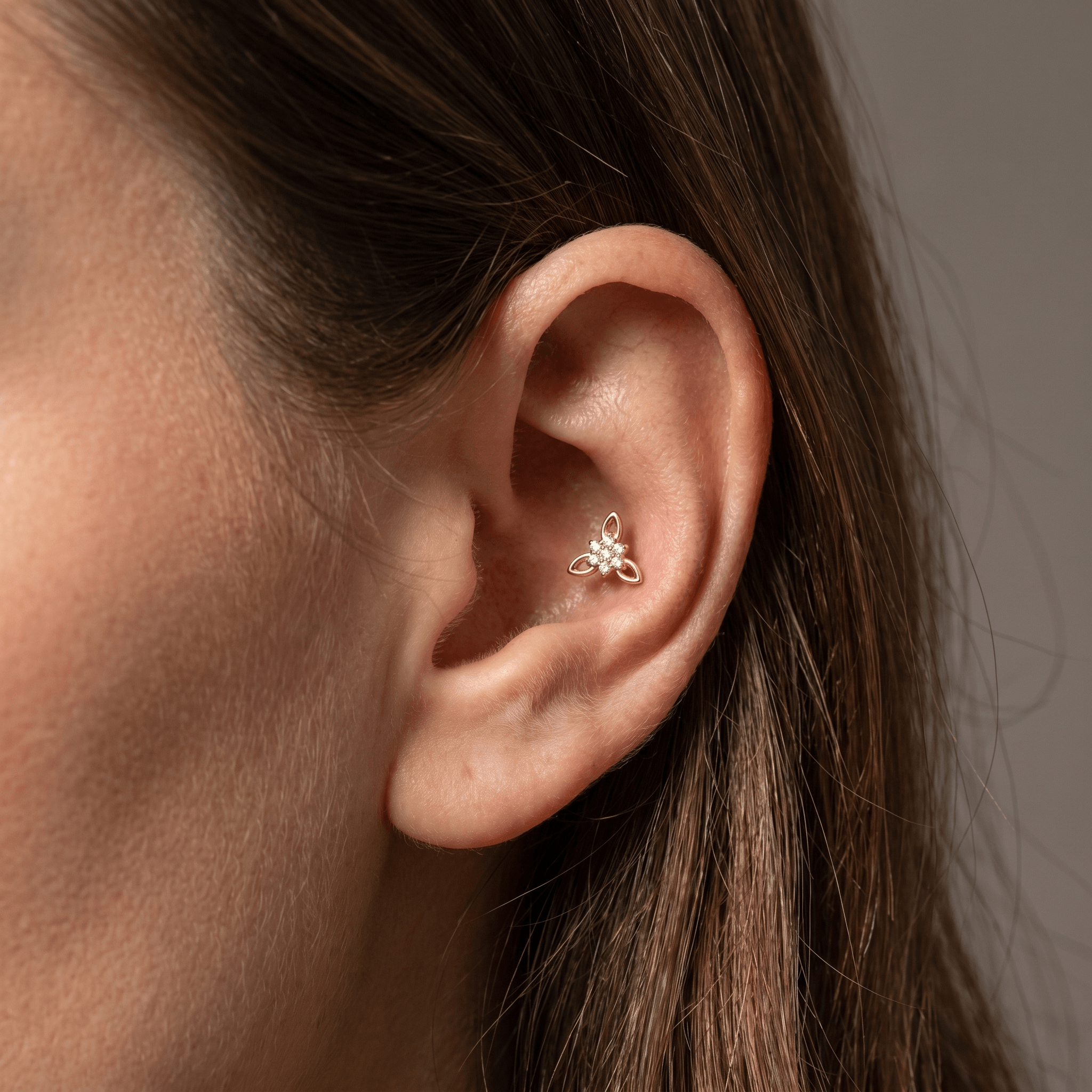 Gold titanium CZ flower cluster piercing stud worn beautifully in a female
