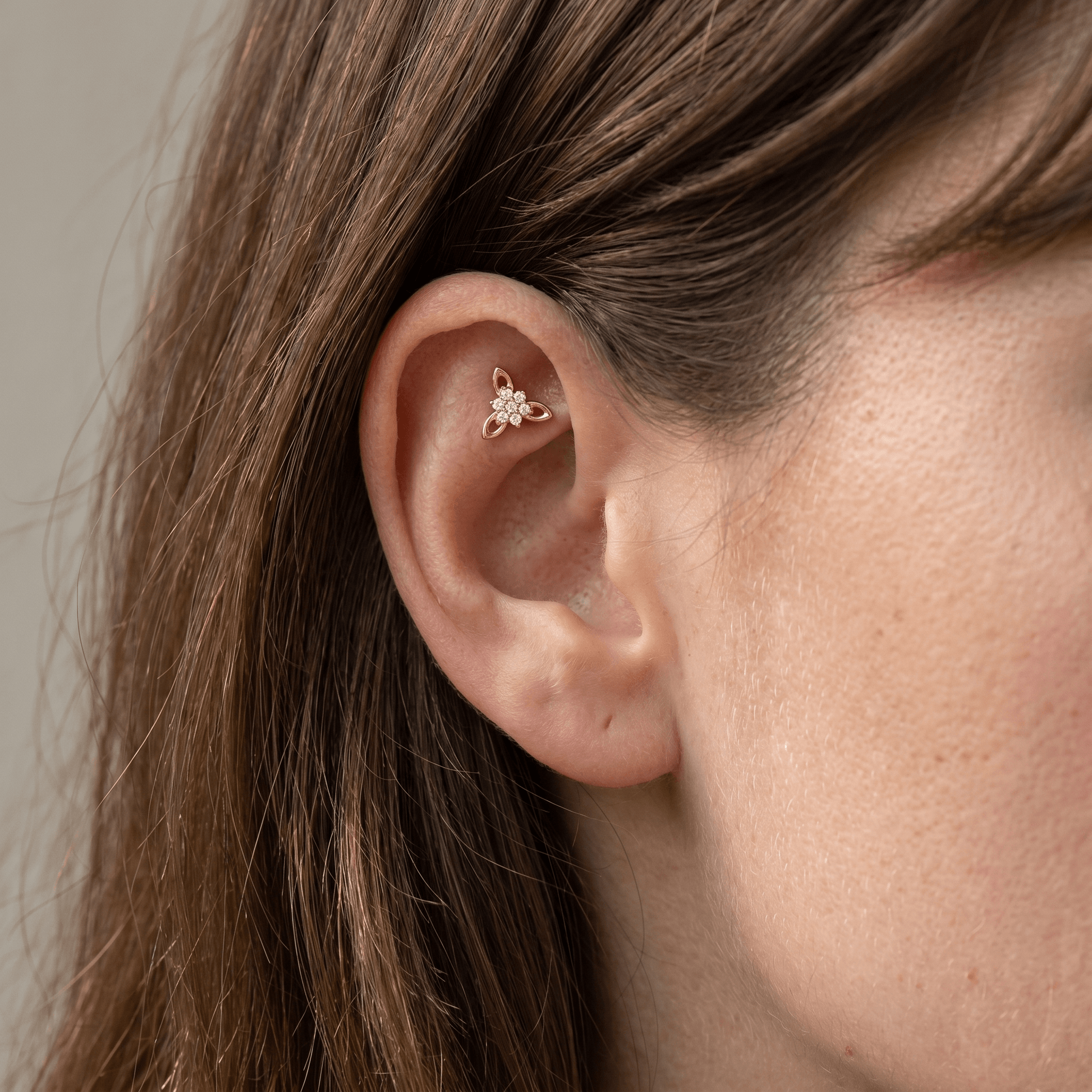 Gold titanium CZ flower cluster piercing stud worn securely in a female