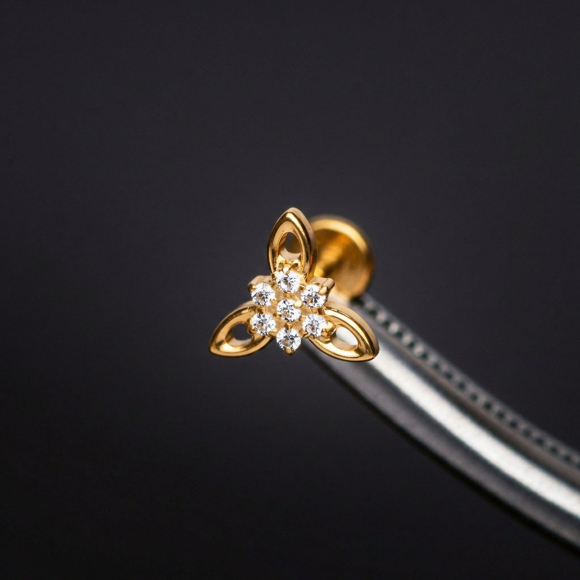 Cz Front Helix Piercing - Tweezers holding a gold