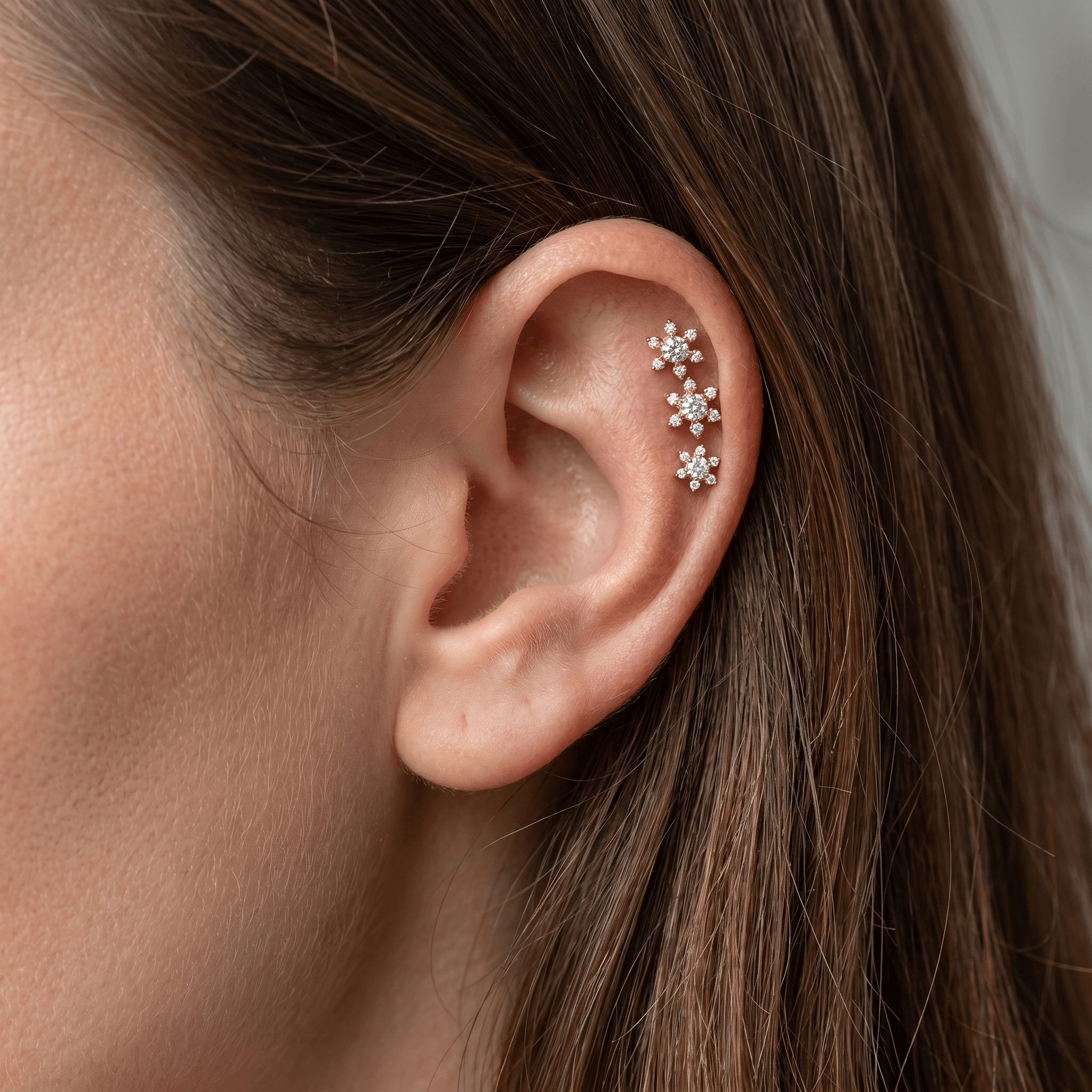Three gold studs worn elegantly in a arrangement.