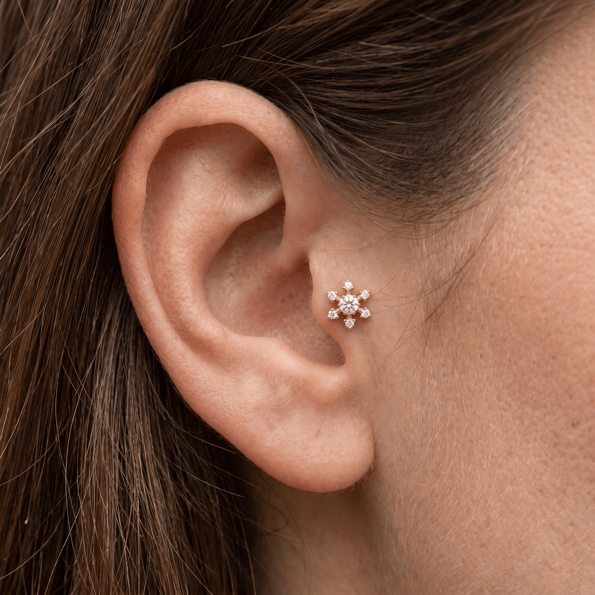 Gold flower piercing stud worn elegantly in a placement.