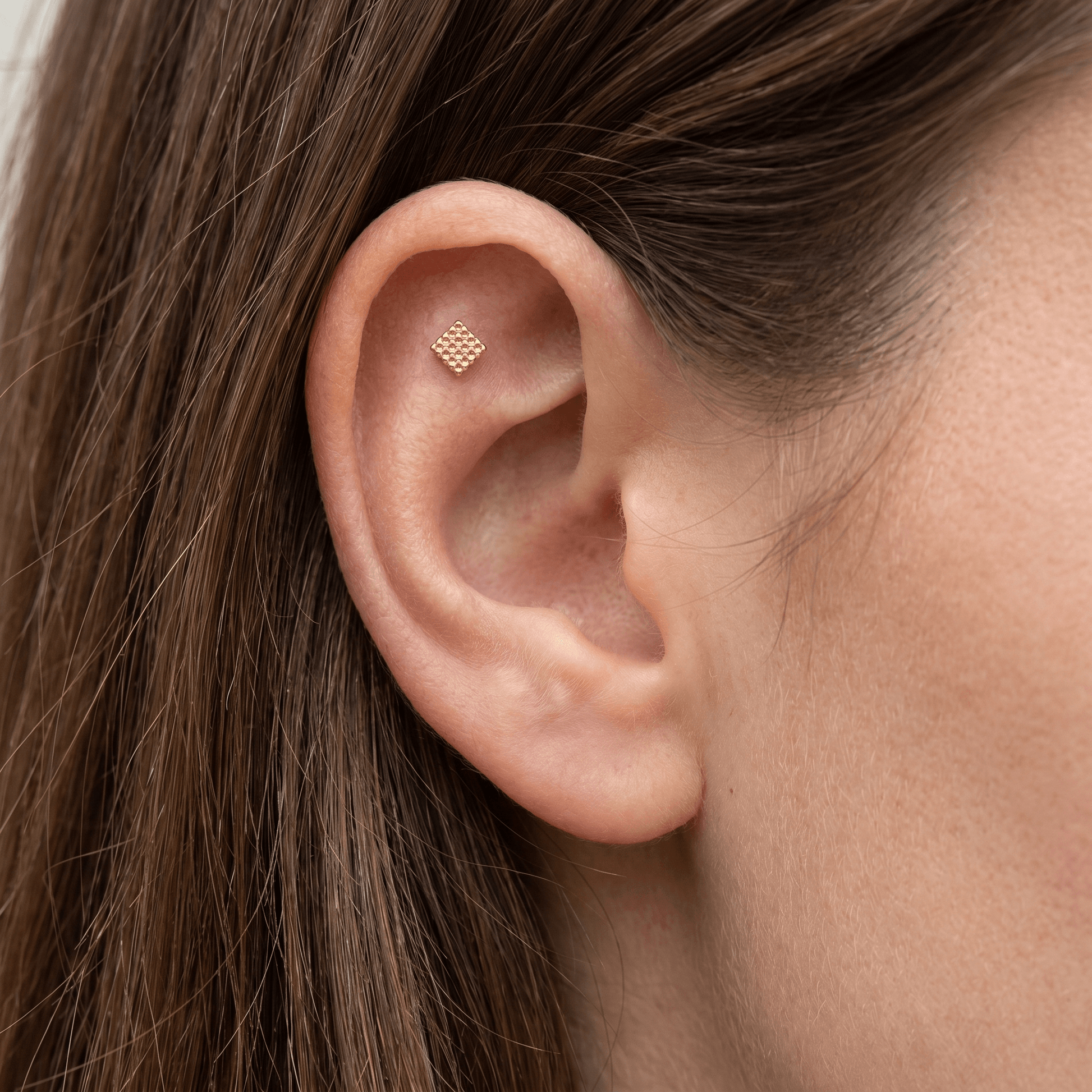 Gold hypoallergenic ear stack jewelry styled in a piercing.