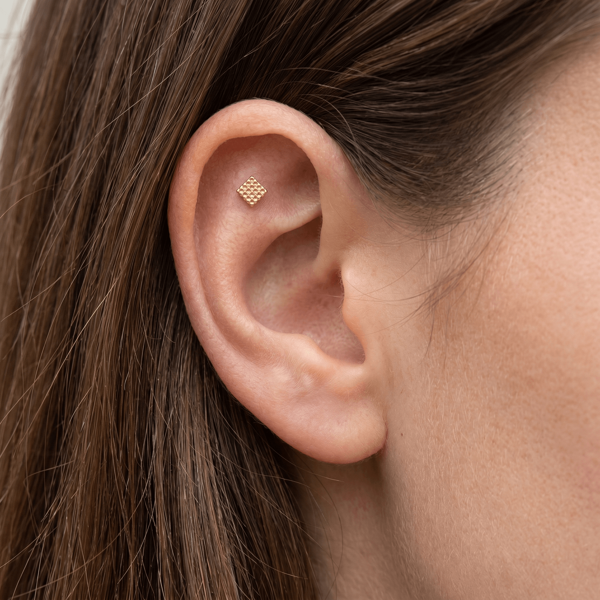 Gold hypoallergenic ear stack jewelry styled in a piercing.