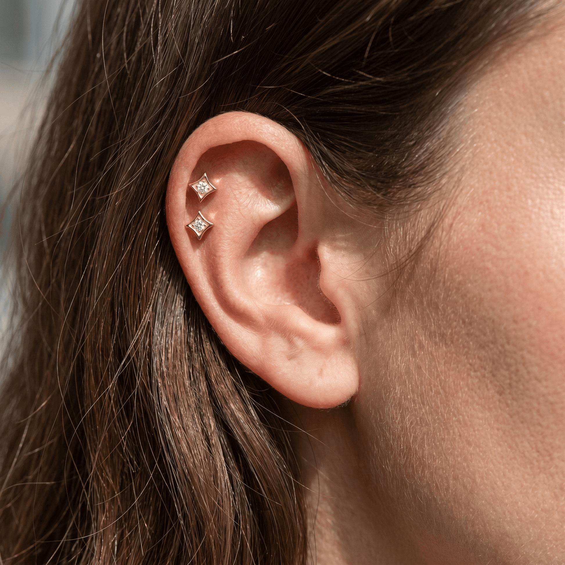 Two gold medical-grade titanium piercings styled in a .