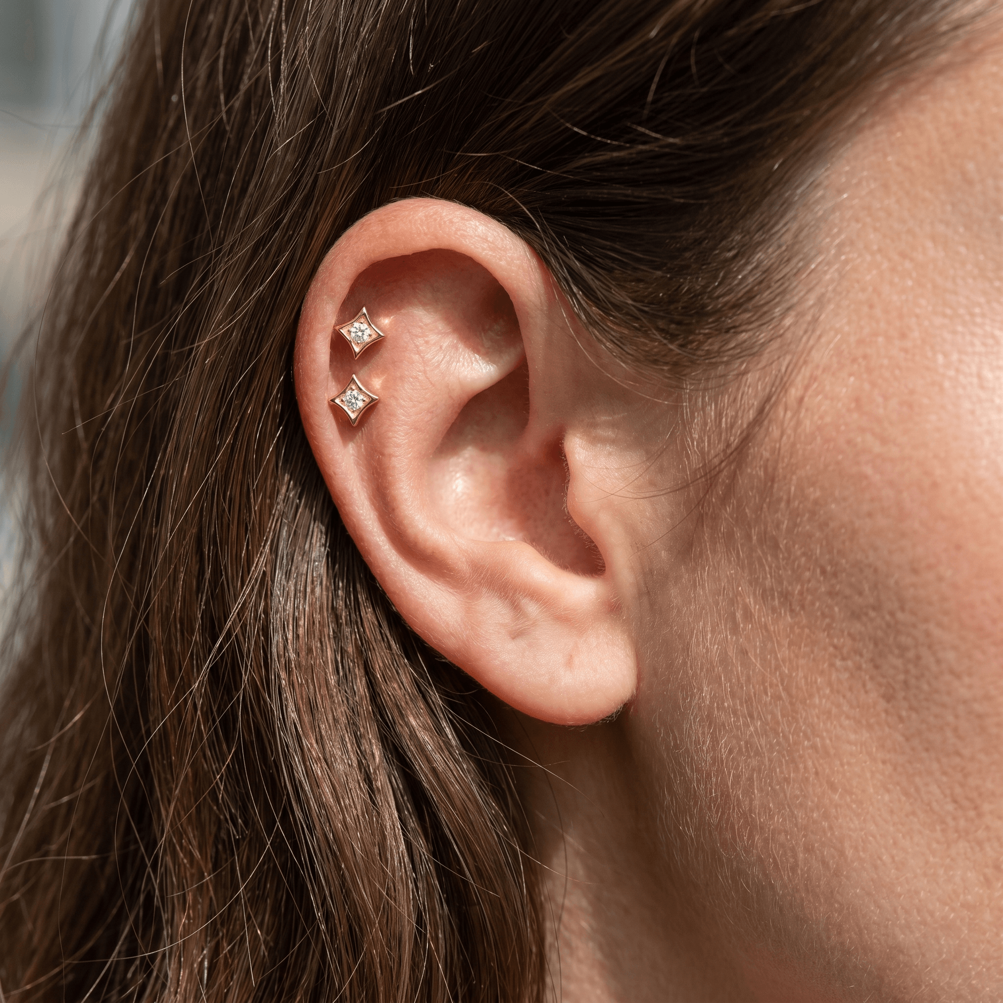 Two gold medical-grade titanium piercings styled in a .
