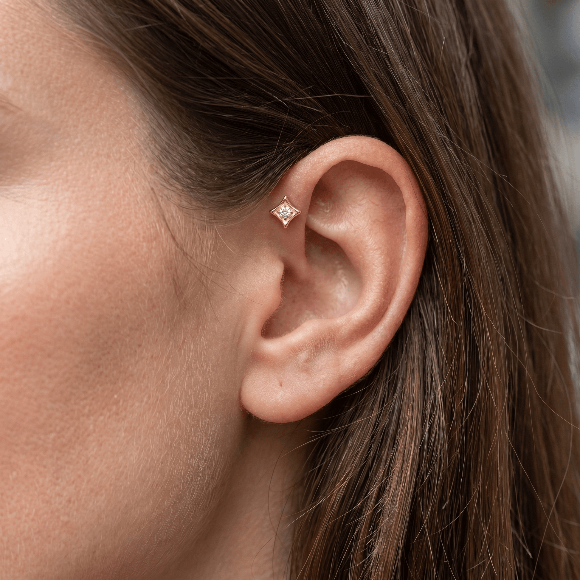 Gold geometric piercing stud worn in a placement.