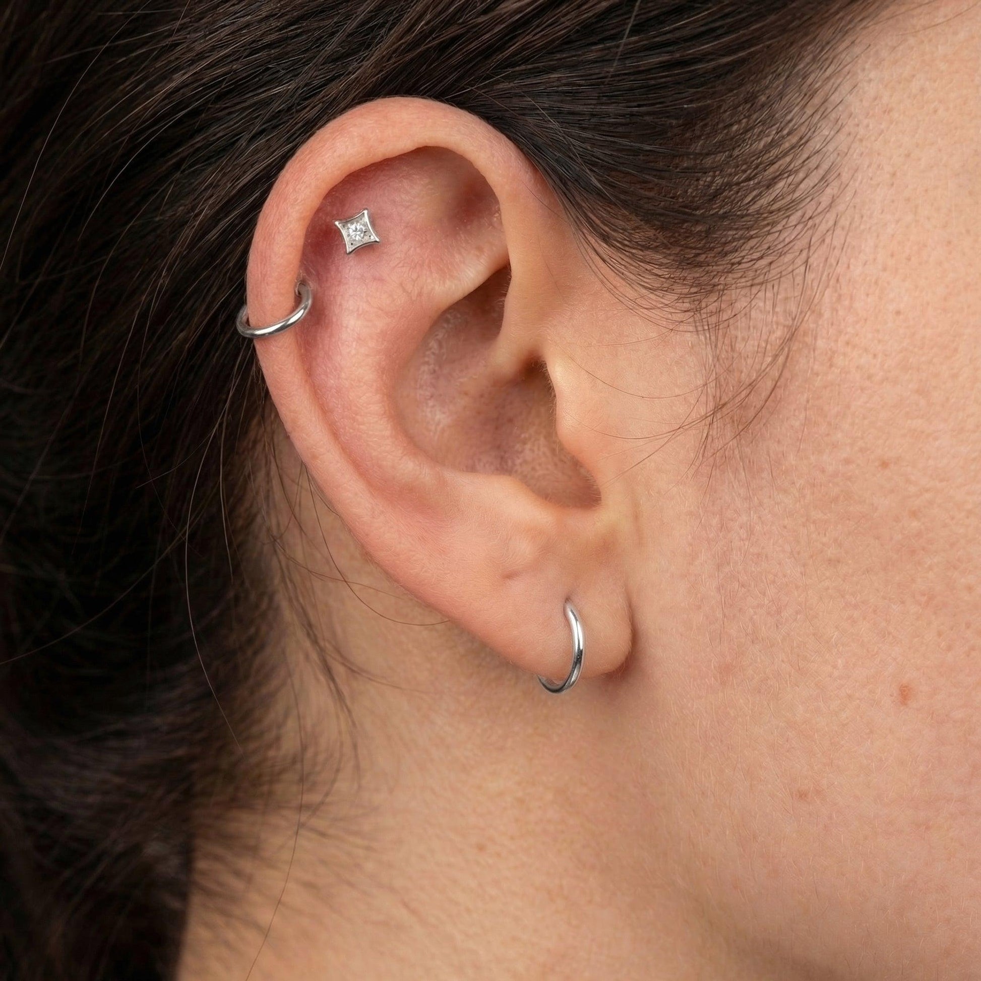 Silver geometric cartilage stud styled perfectly alongside a silver hoop.