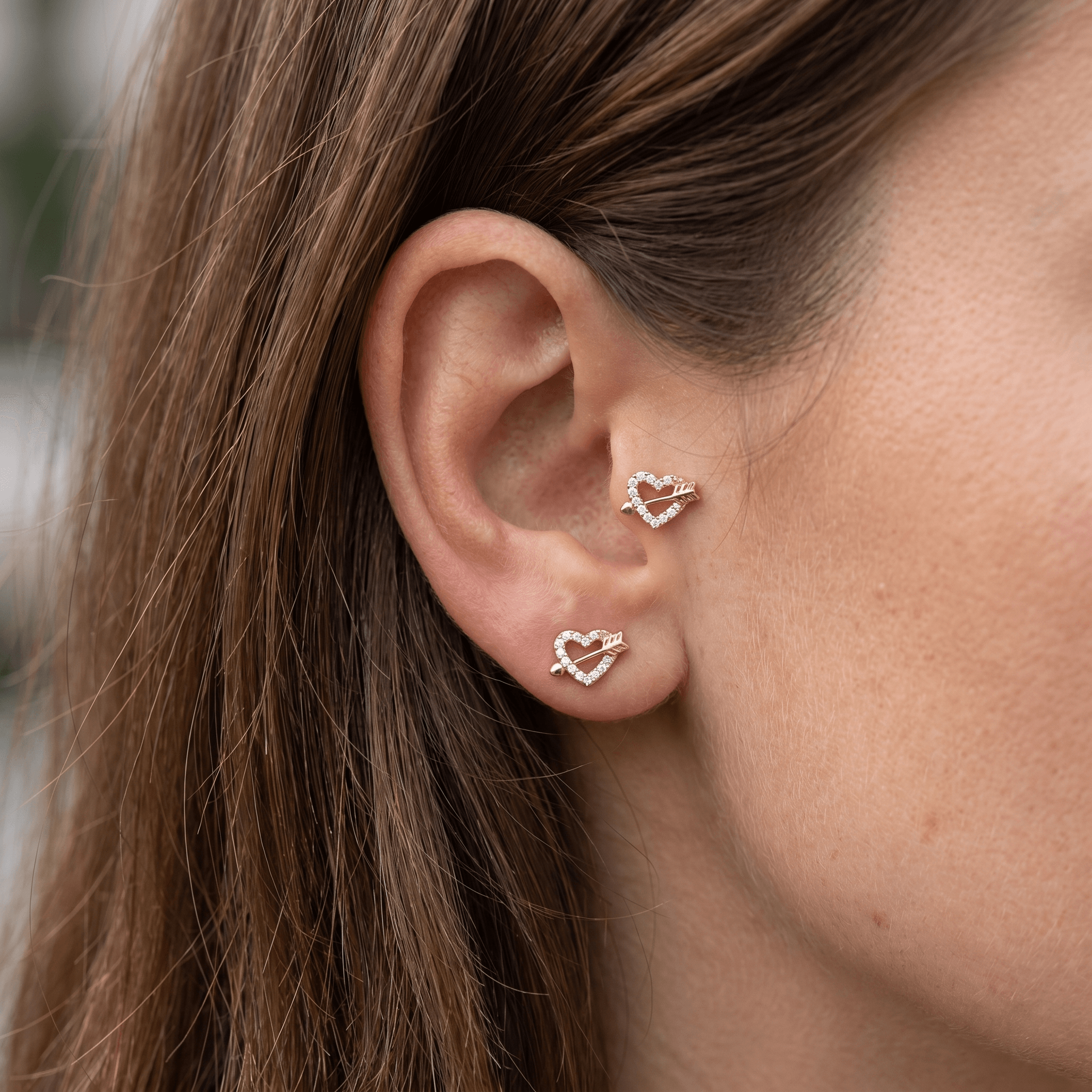 Gold heart arrow stud styled perfectly in an and ear piercing.