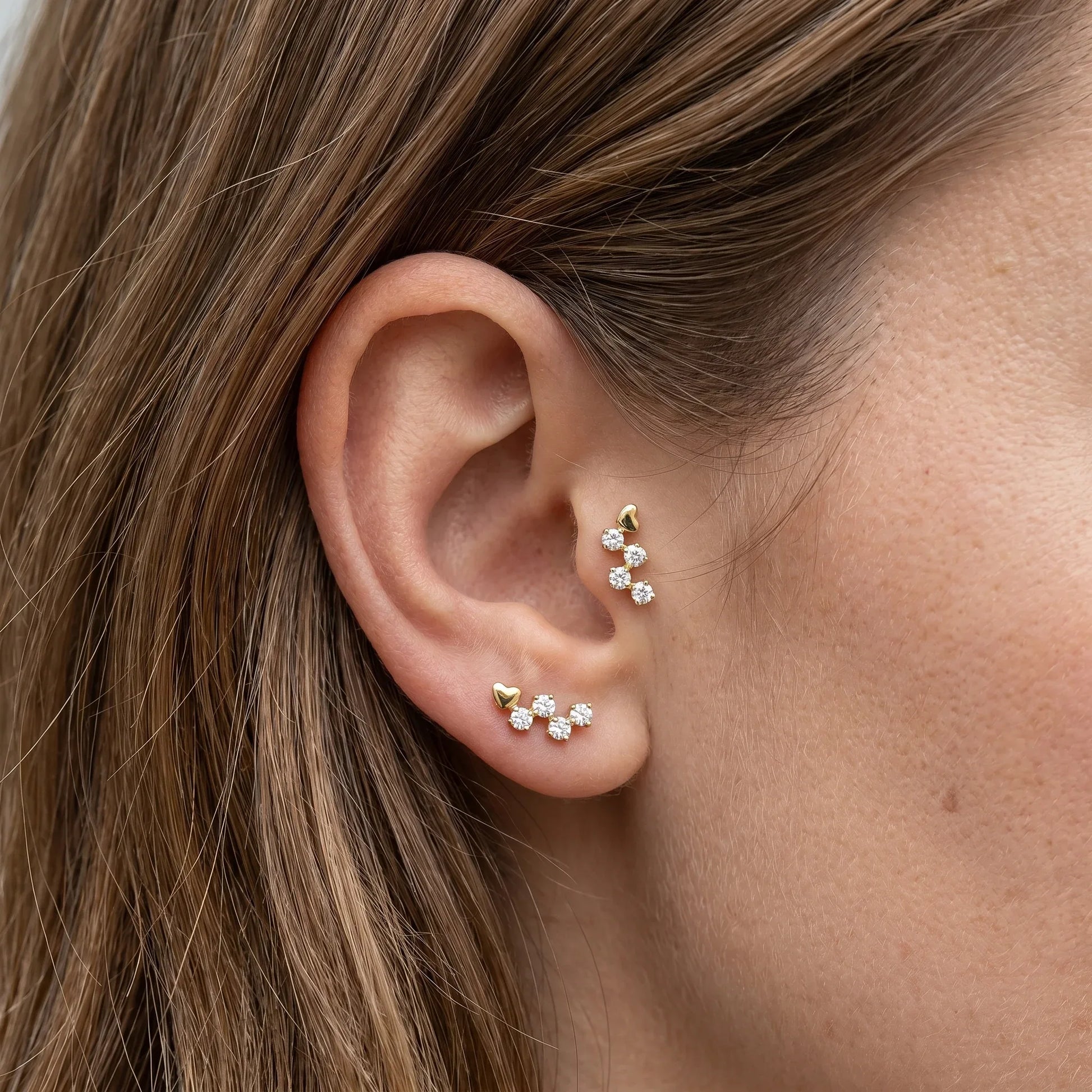 Gold romantic cartilage styled in tragus antitragus piercings.