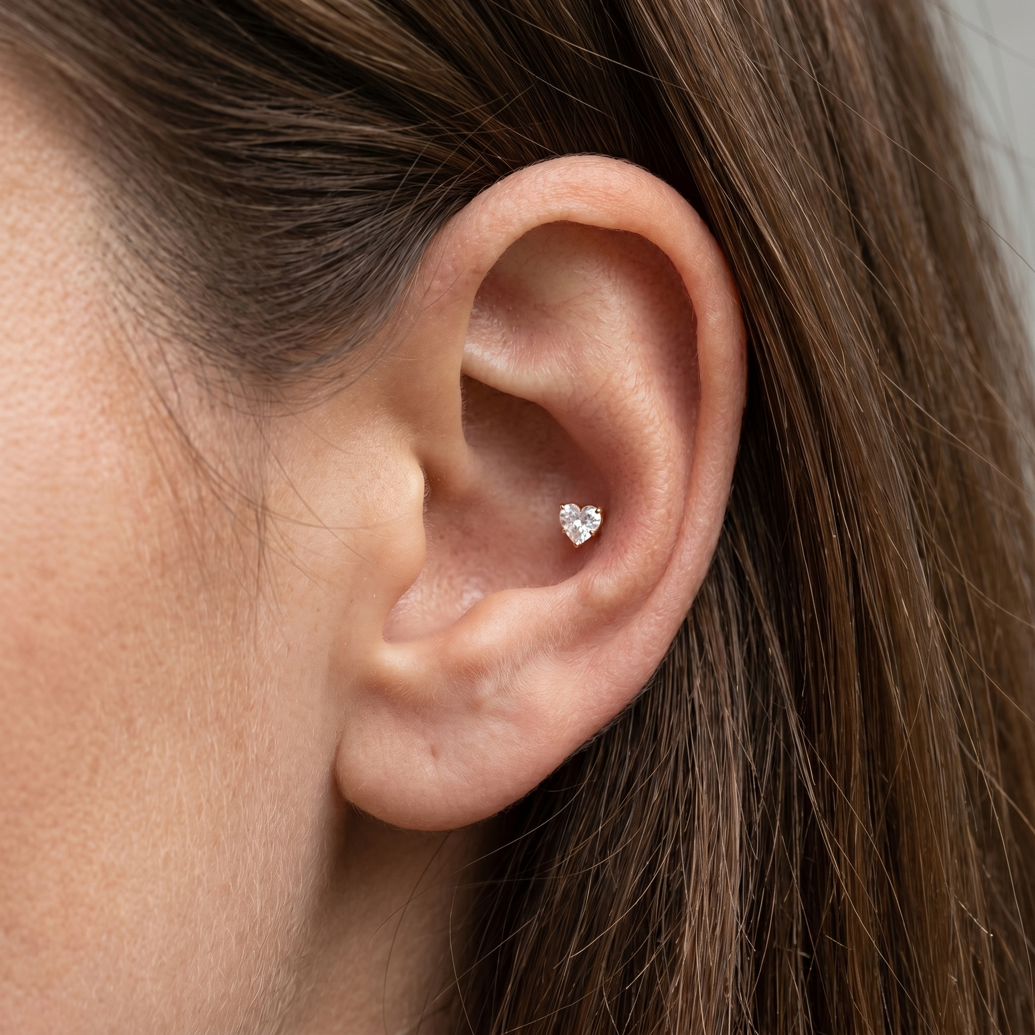 Gold heart faux stud worn gracefully in an placement.