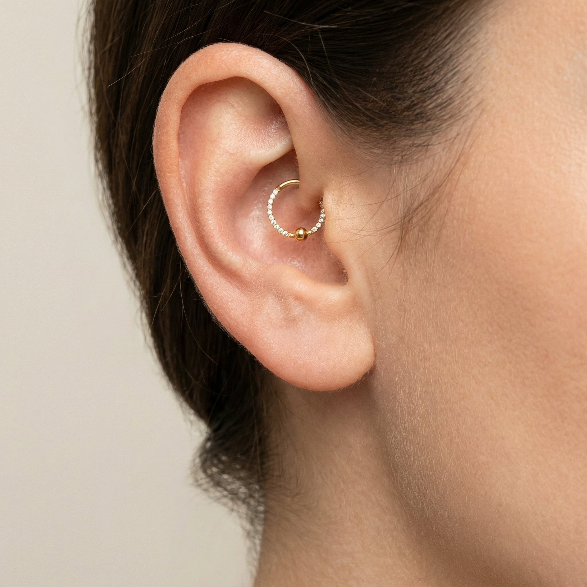 Close-up of a gold zircon center bead clicker ring styled perfectly in