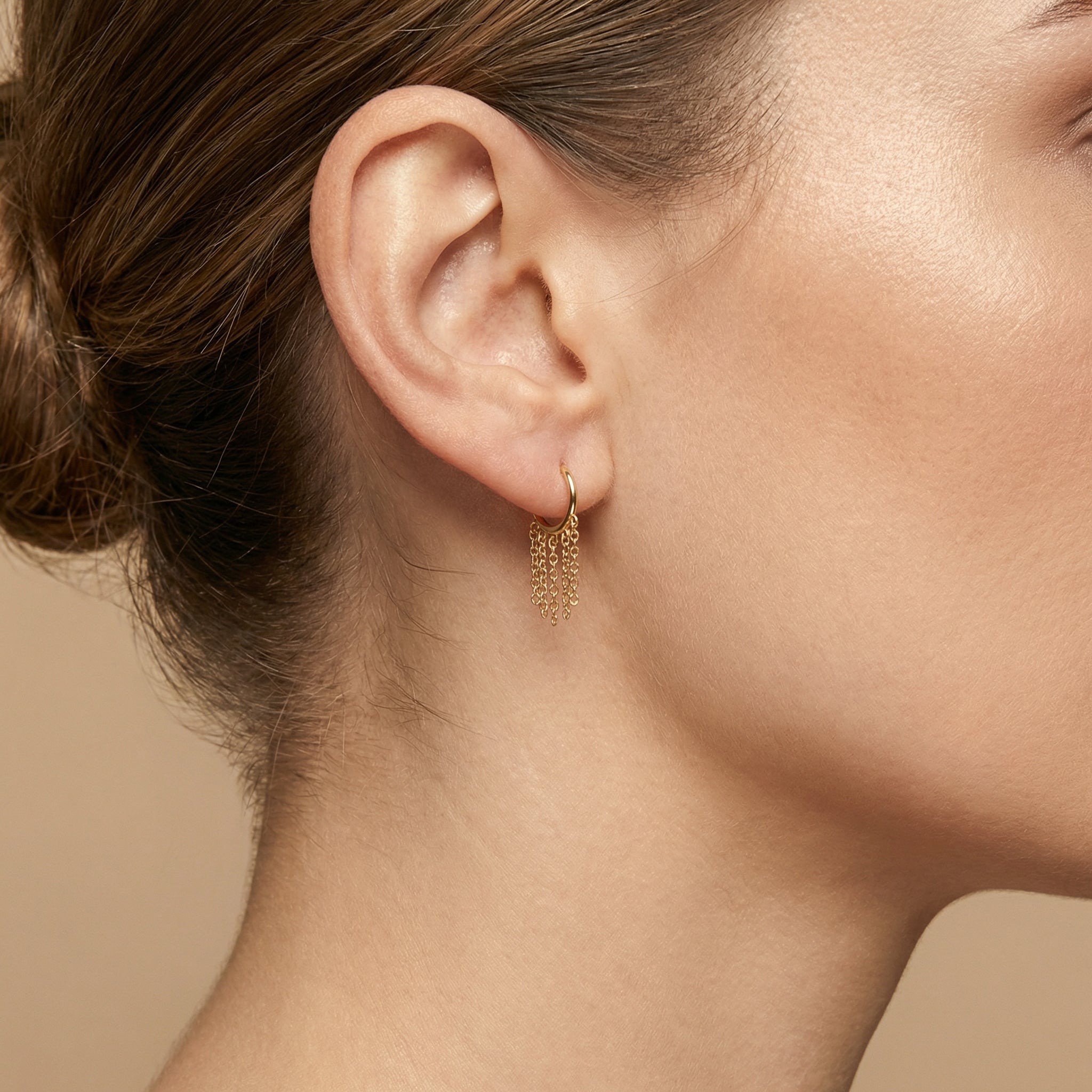 Gold dangling chain clicker ring worn comfortably in a model's standard lower
