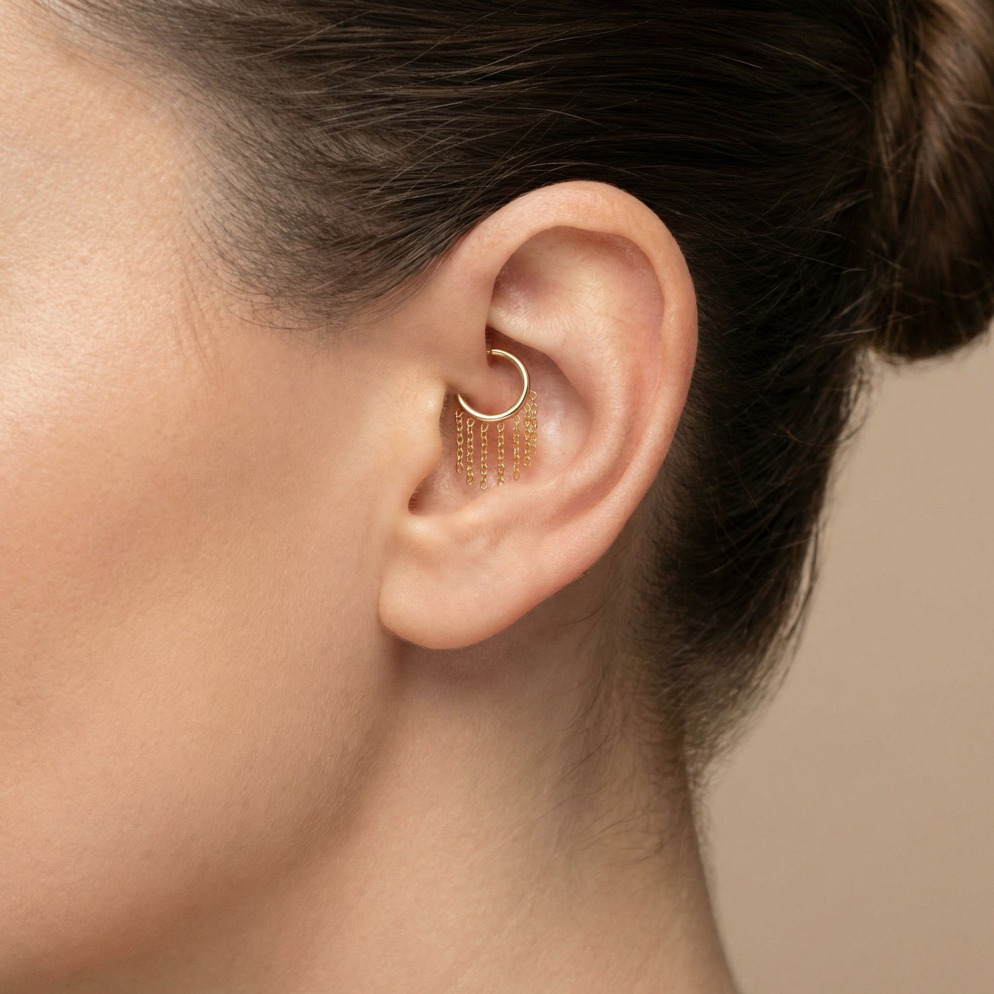 Gold dangling chain clicker hoop styled perfectly inside the inner ear cartilage