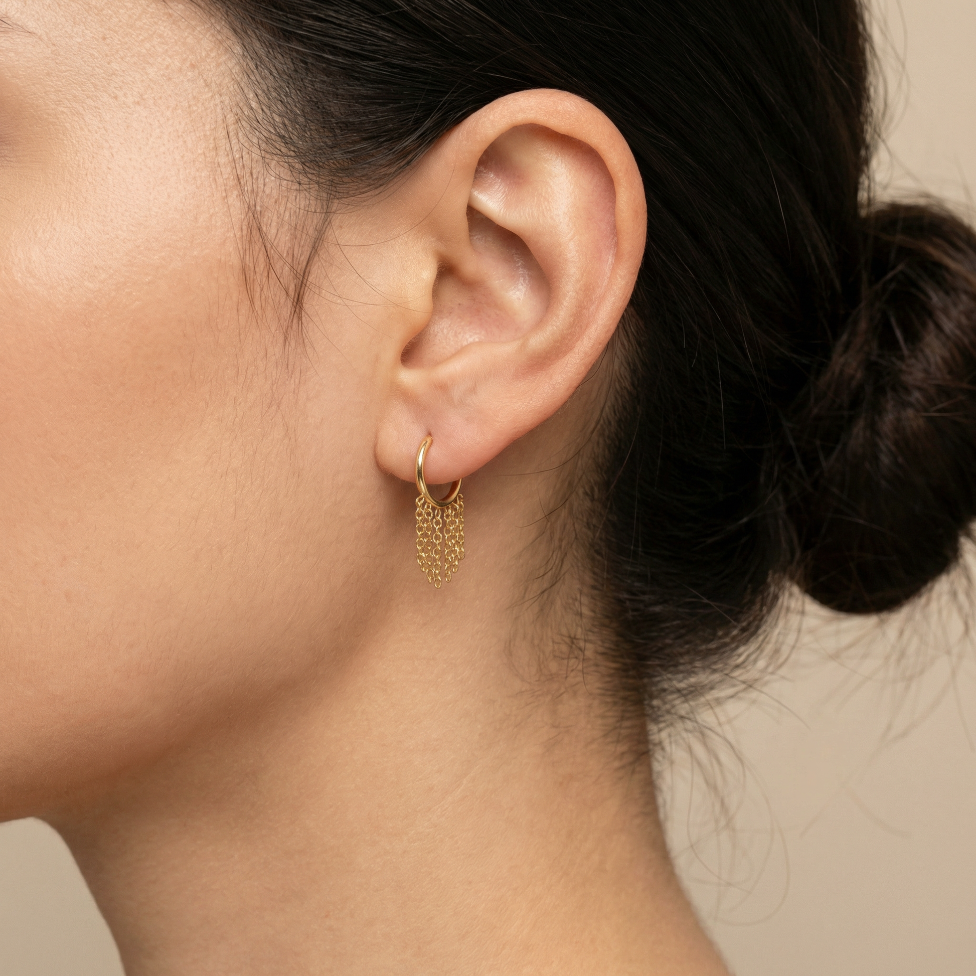 Close-up profile of a gold dangling chain clicker ring styled perfectly in