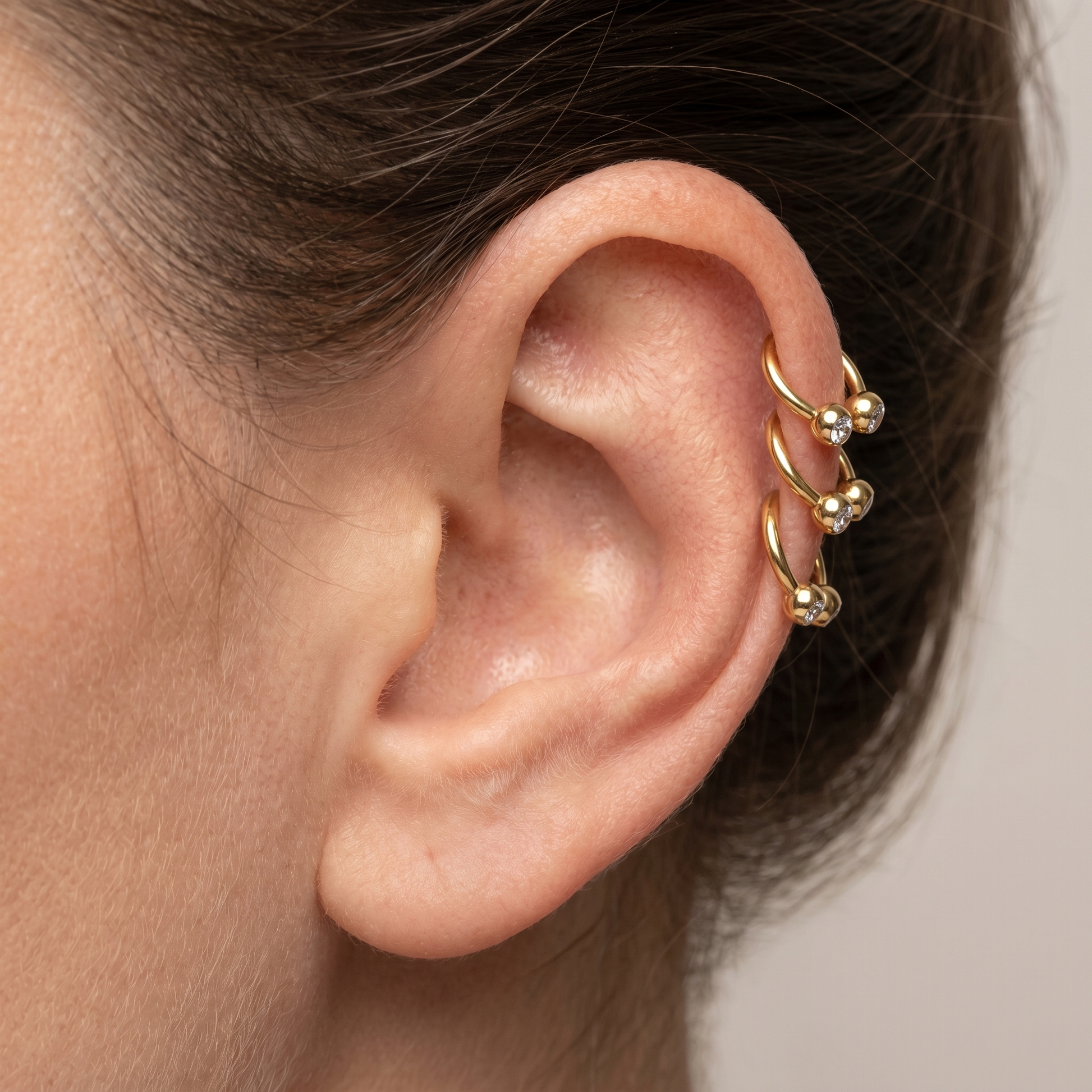 Gold crystal ball horseshoe stud — triple helix piercing placement