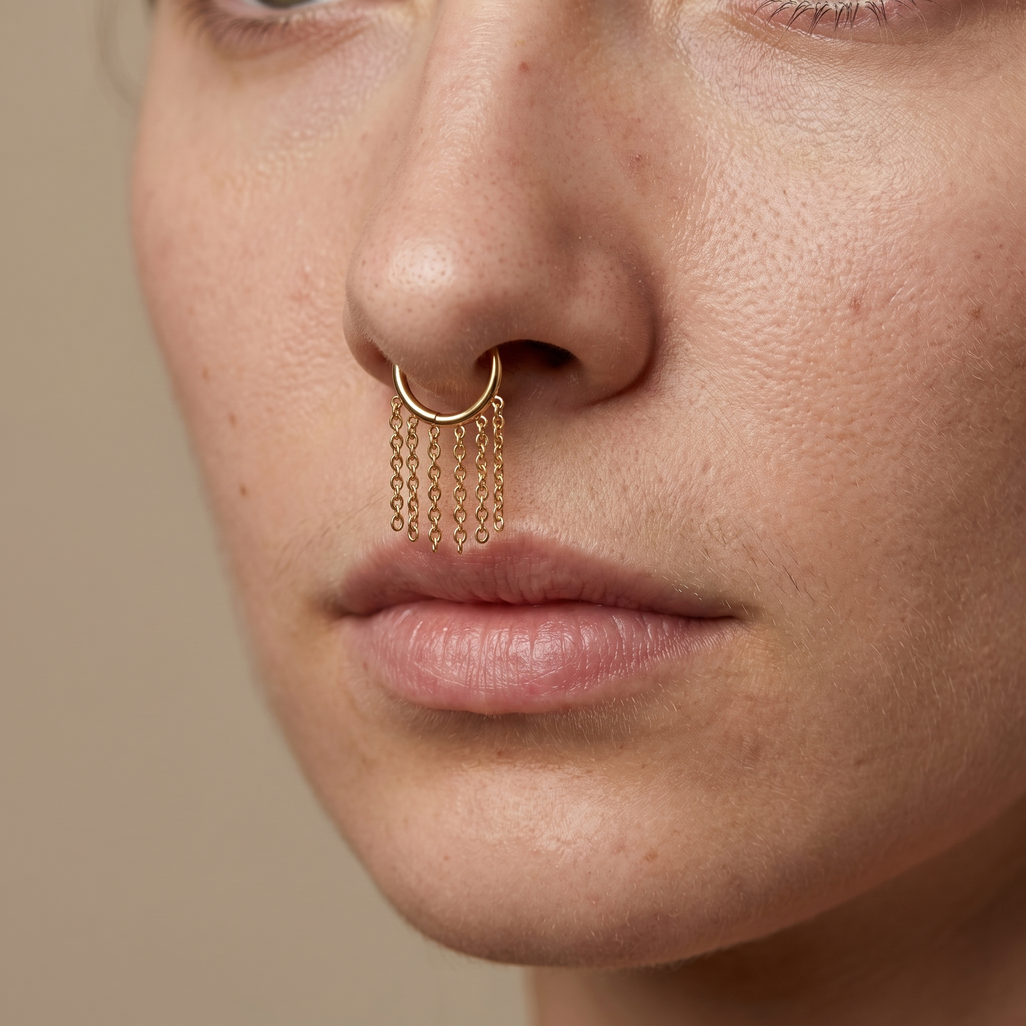 Frontal view of a model wearing a gold dangling chain clicker ring