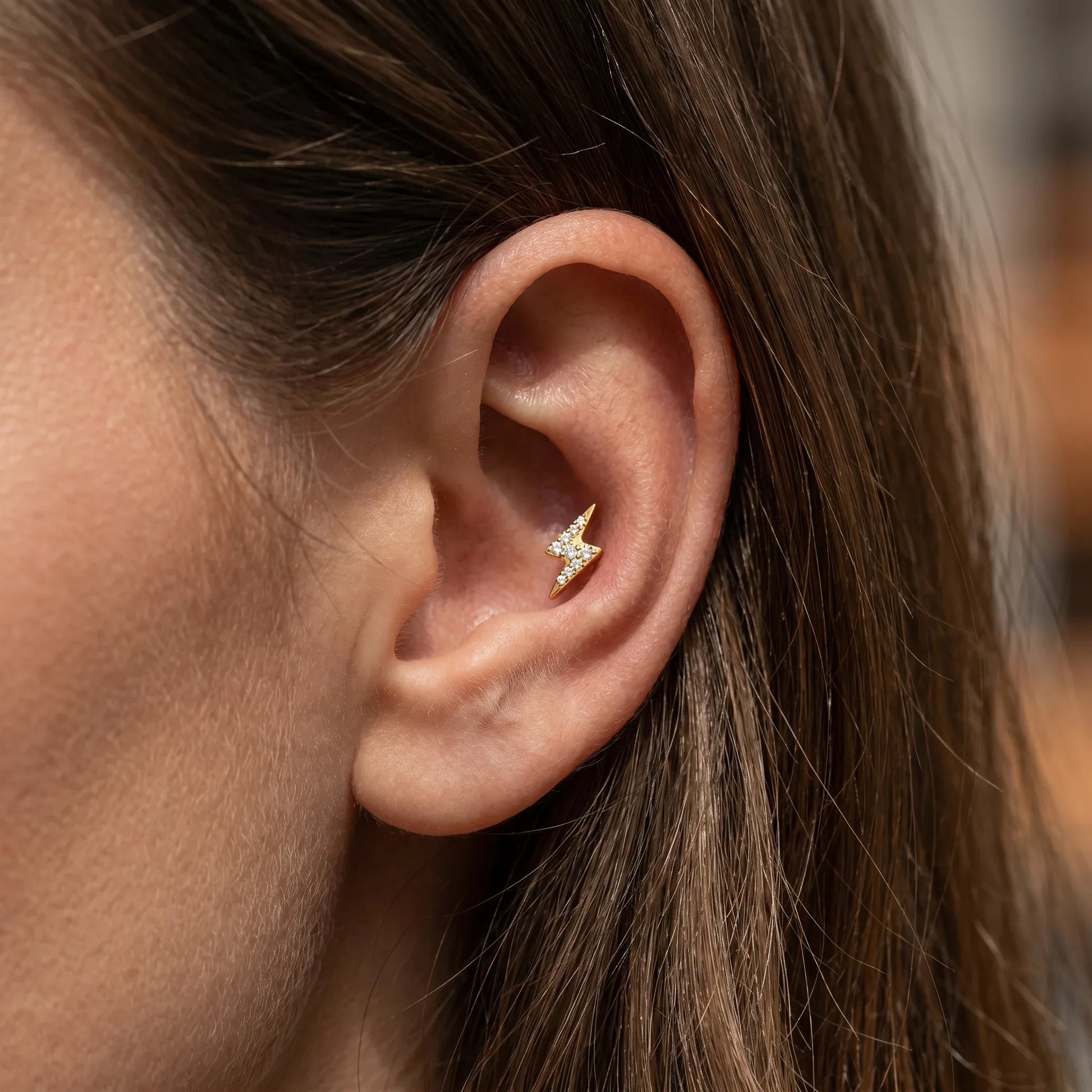 Gold lightning bolt outer piercing jewelry in a 16G.