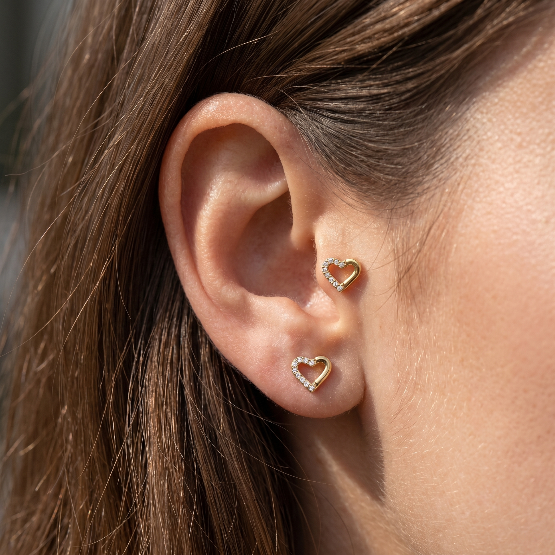 Cartilage Ear Piercing Earrings - Two gold open heart studs styled cleanly tragus antitragus piercings.