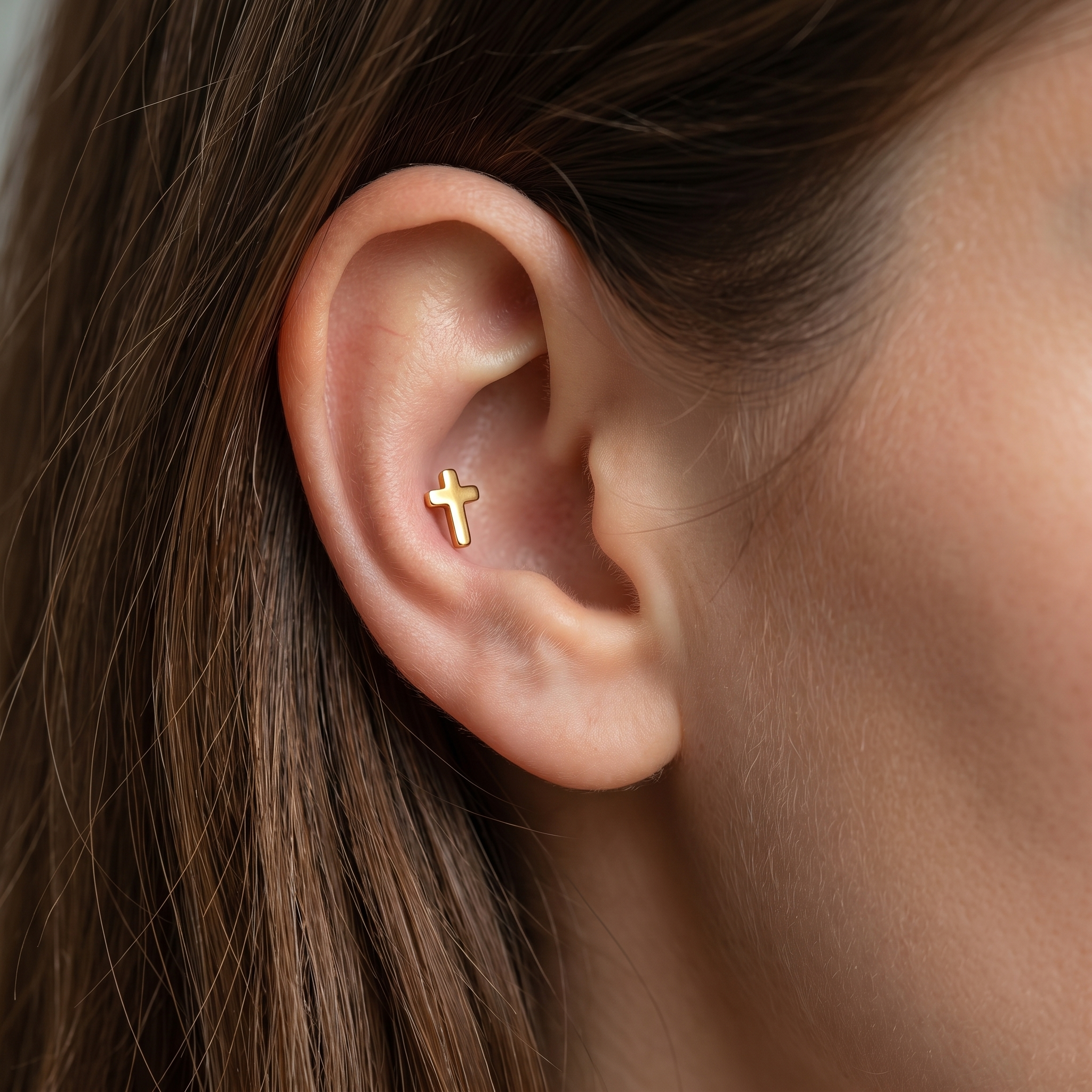 Gold minimalist cross stud — outer conch piercing placement