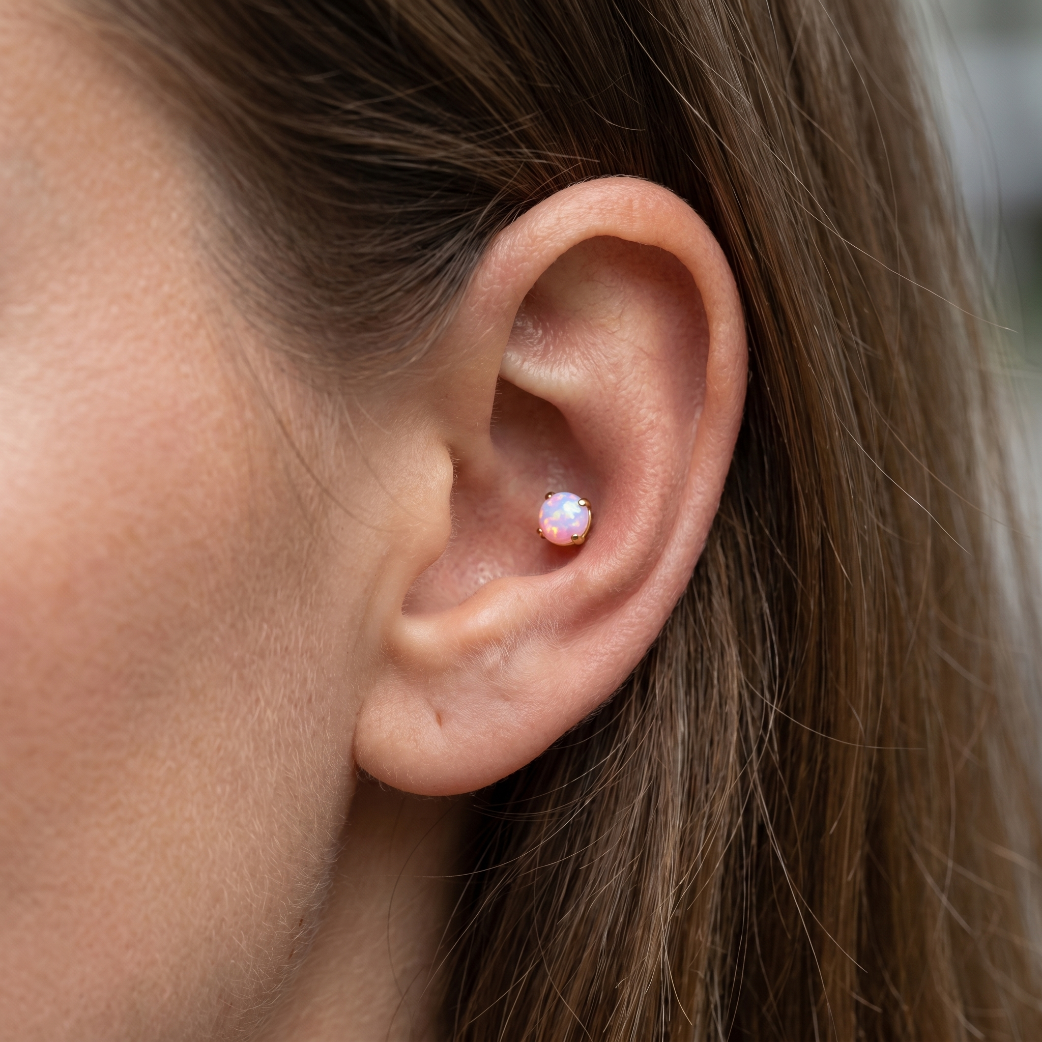 Pink opal cartilage stud worn perfectly in an outer piercing.