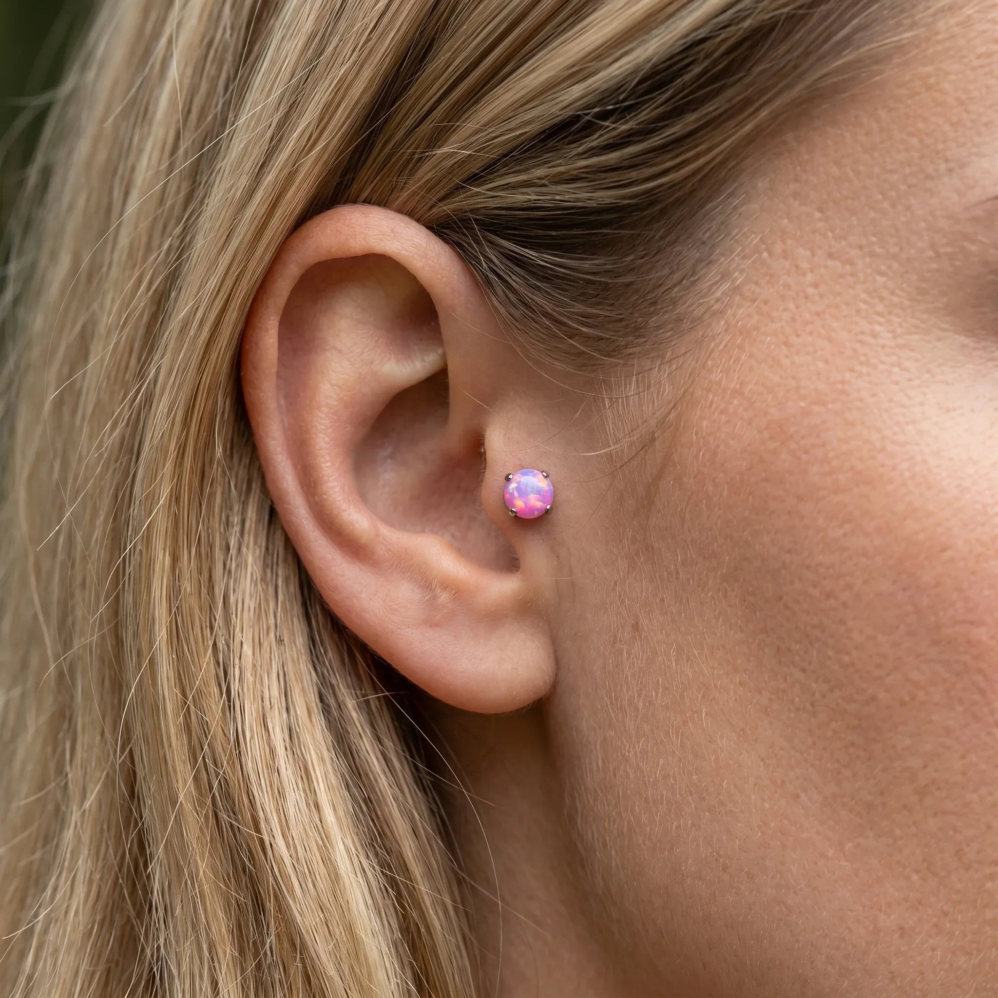 Pink opal titanium stud worn gracefully in a piercing.