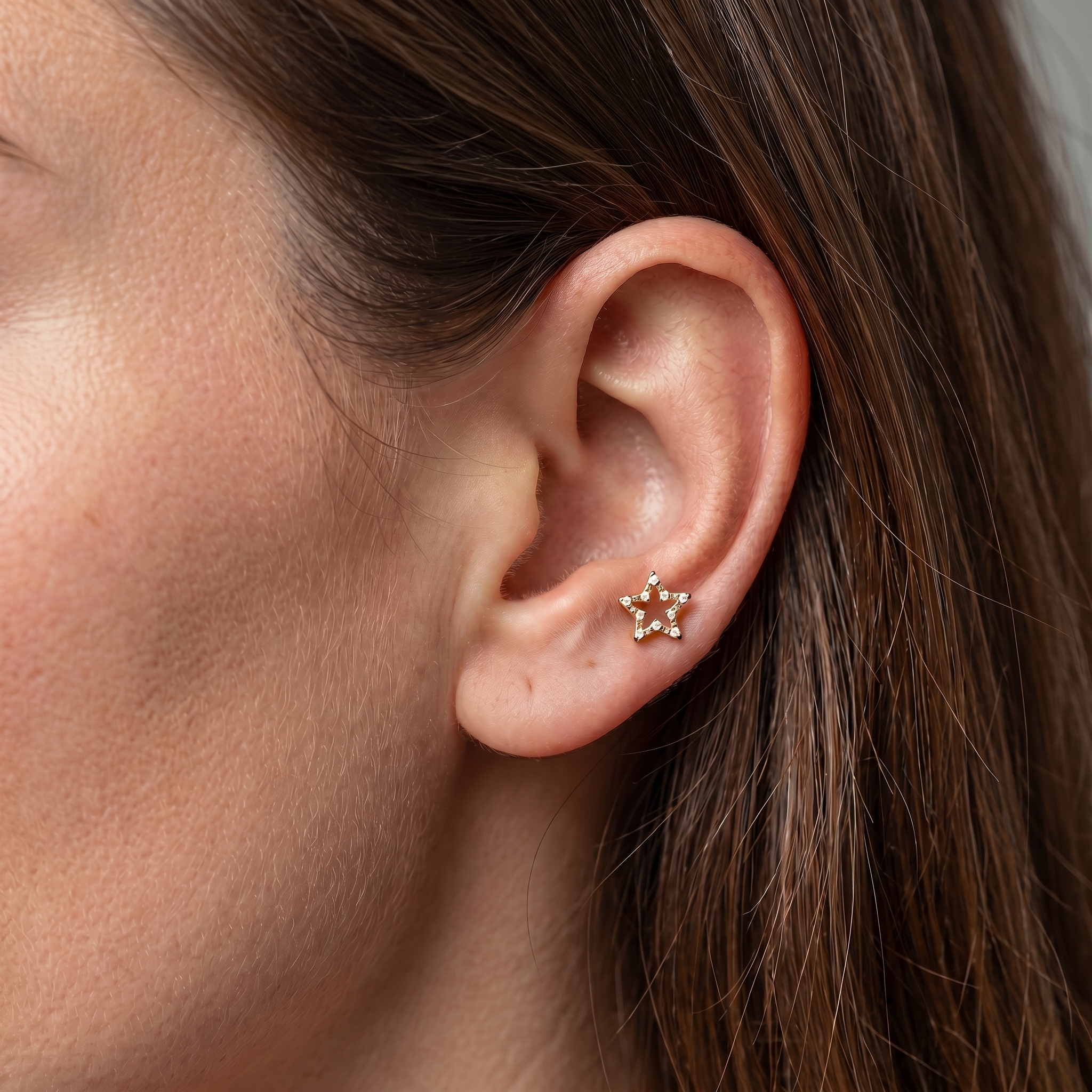 Gold open star zircon stud — anti tragus placement