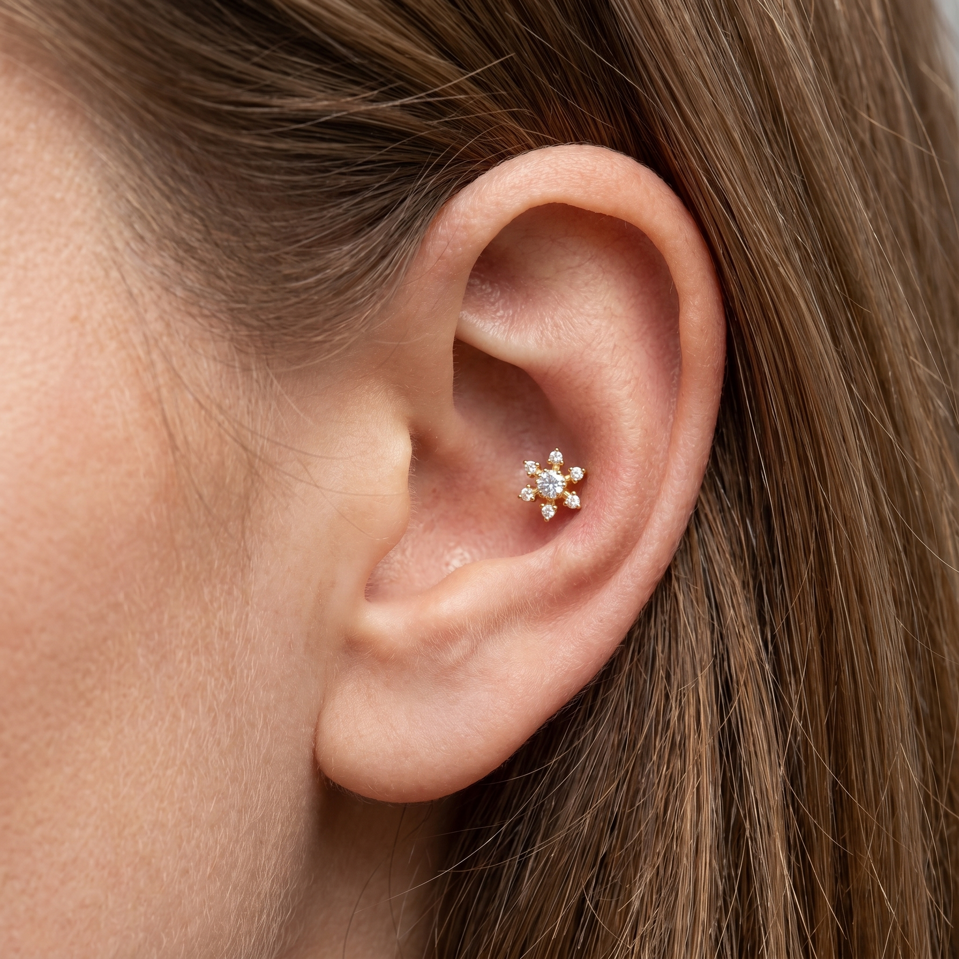 Gold flower zircon stud — conch ear placement