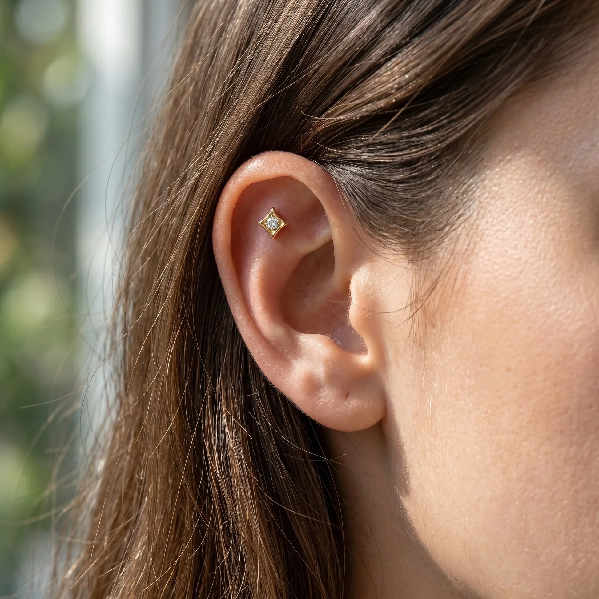 Gold geometric cartilage stud worn beautifully in a piercing.