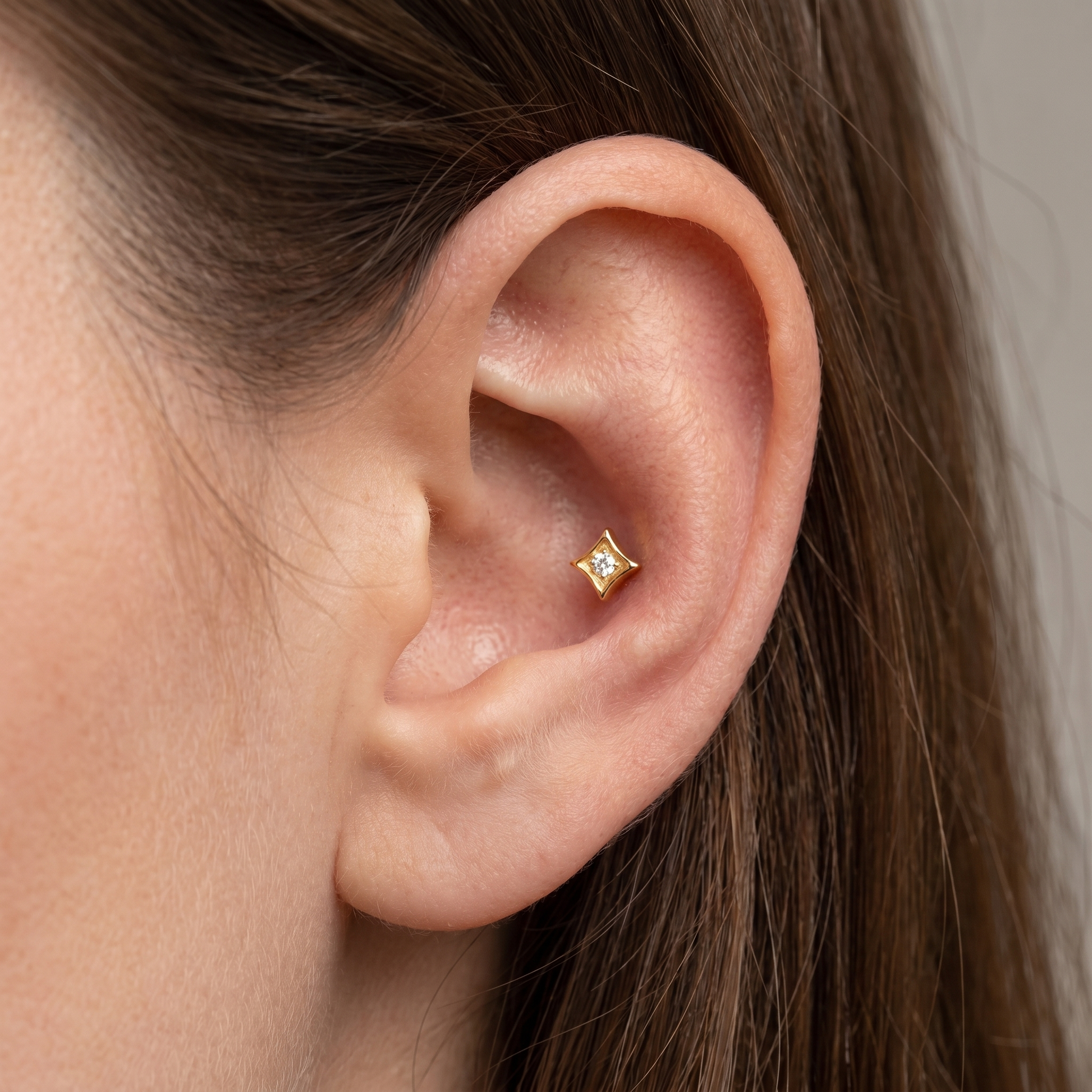 Gold geometric cartilage stud styled elegantly in an piercing.