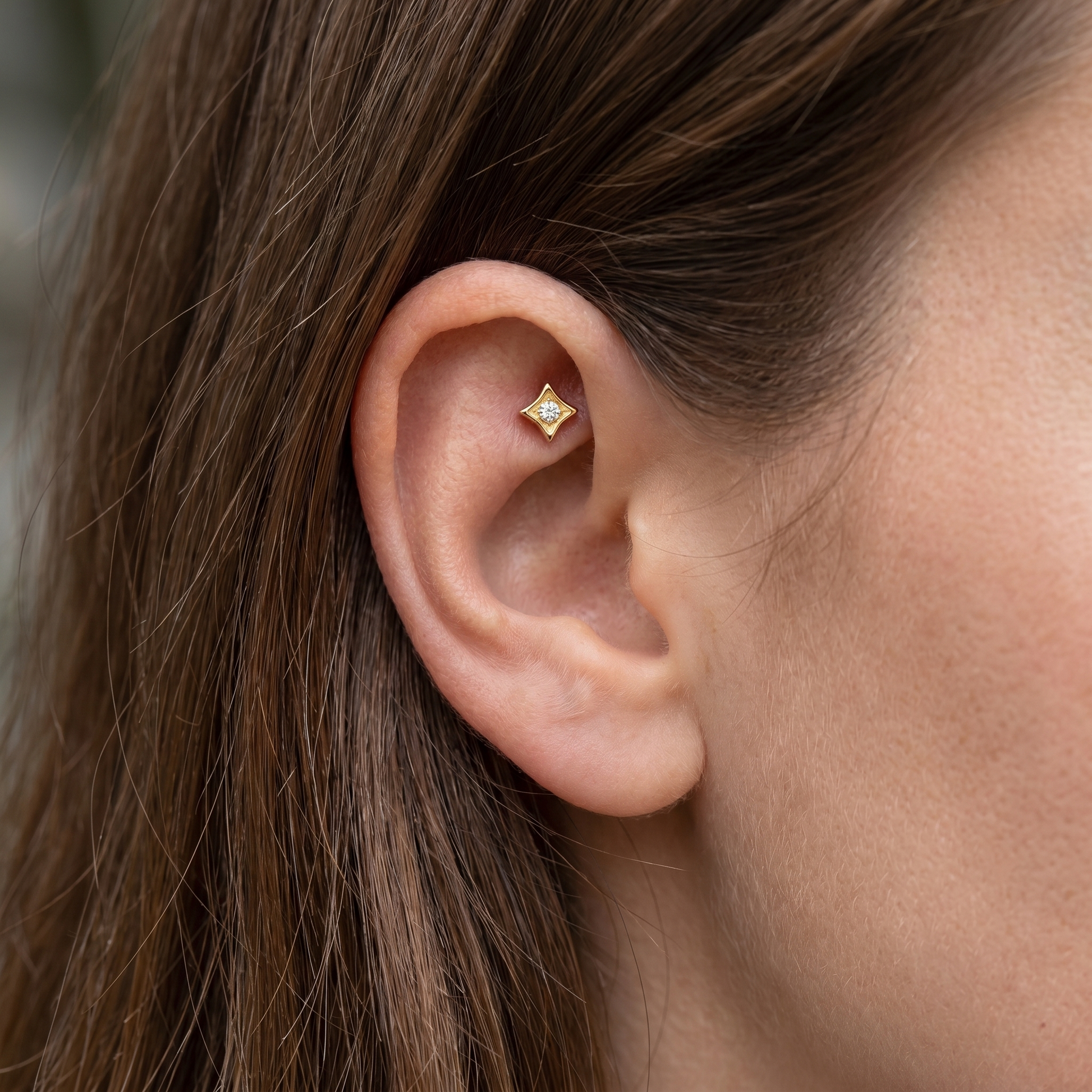 Gold geometric cartilage stud styled elegantly in an faux piercing.