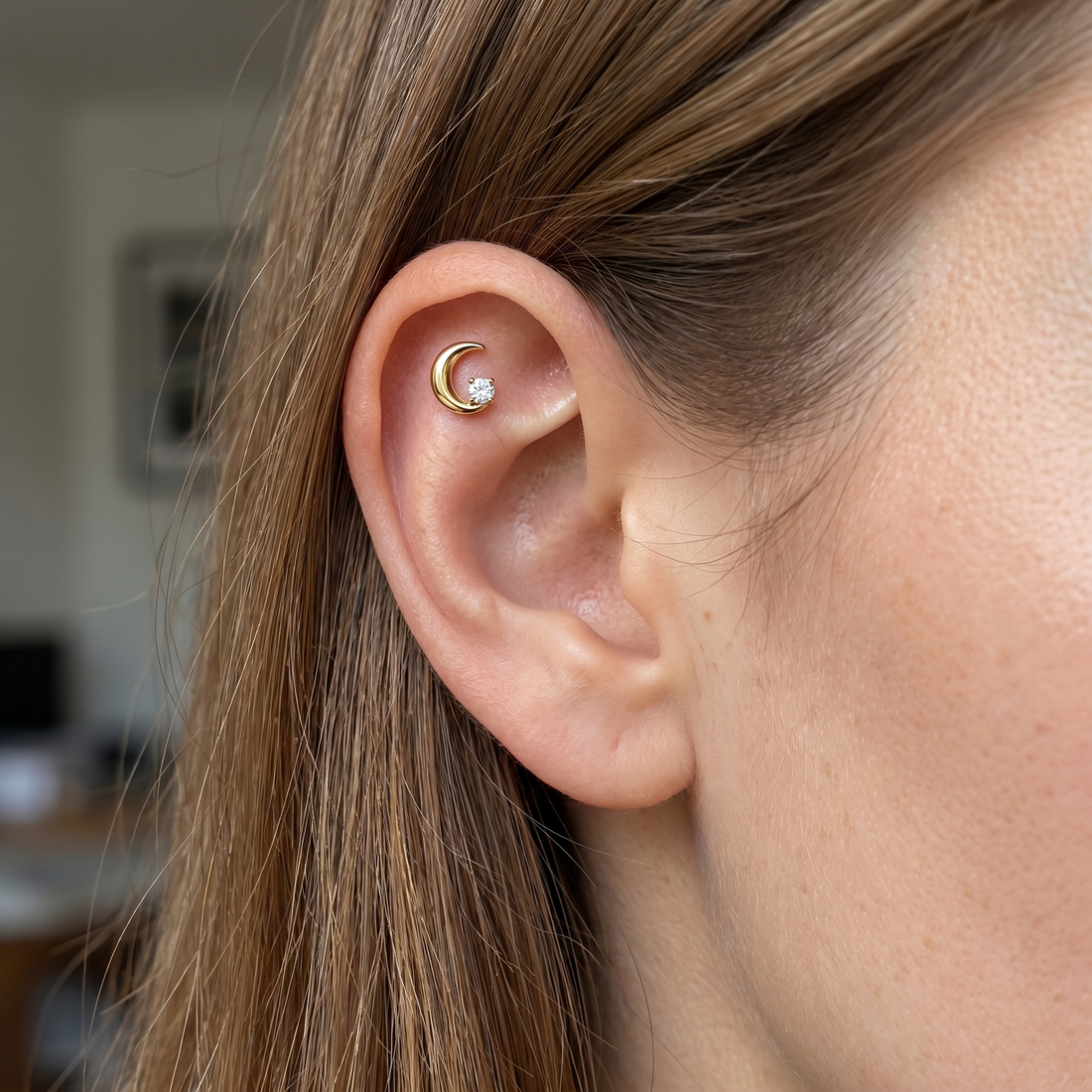 Gold crescent moon zircon stud — flat helix piercing placement