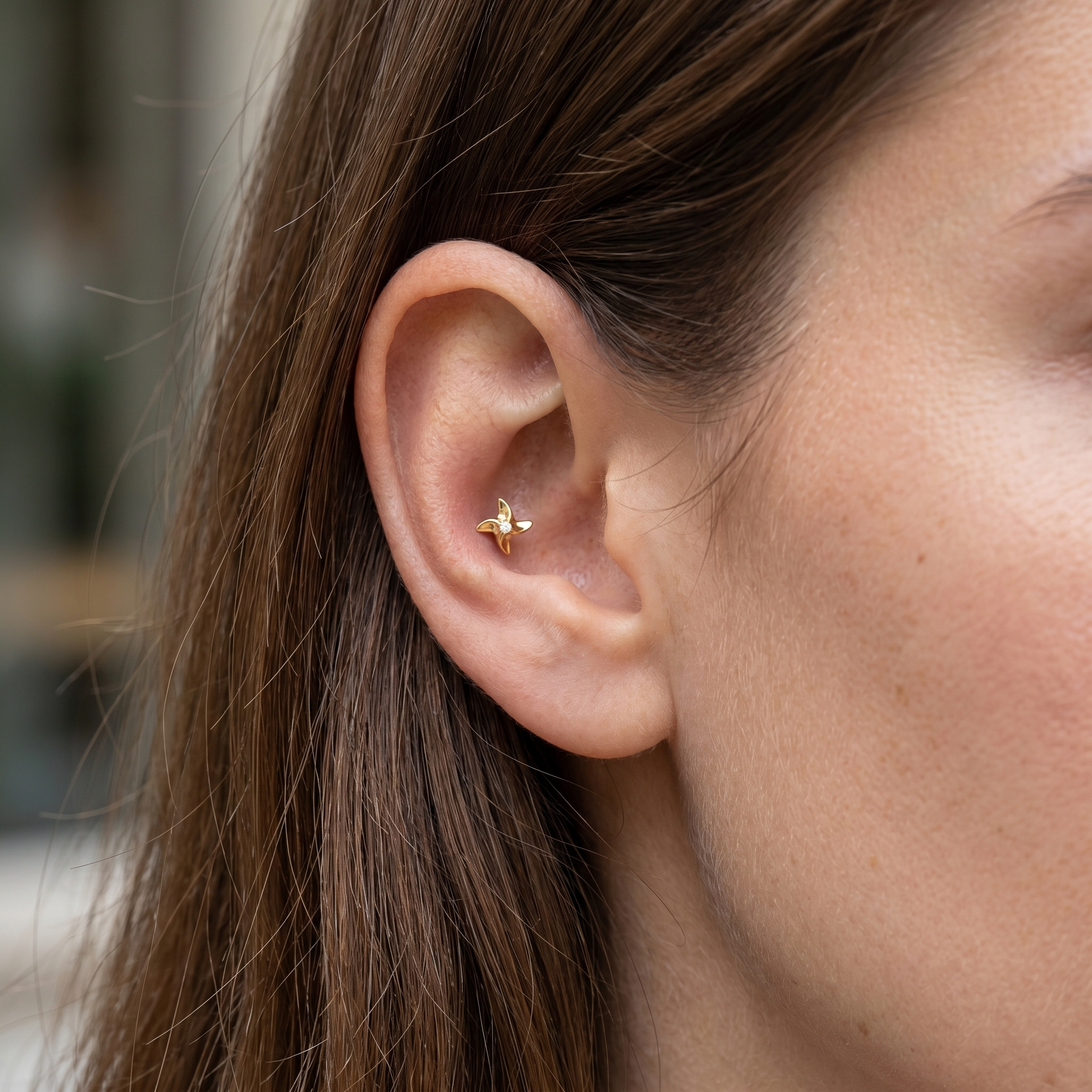 Gold pinwheel piercing stud styled in an piercing.