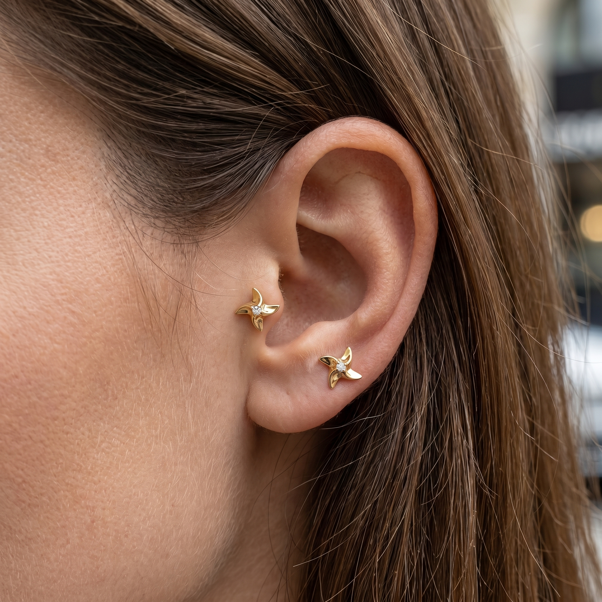 Gold playful ear stack jewelry worn in a tragus antitragus placements.