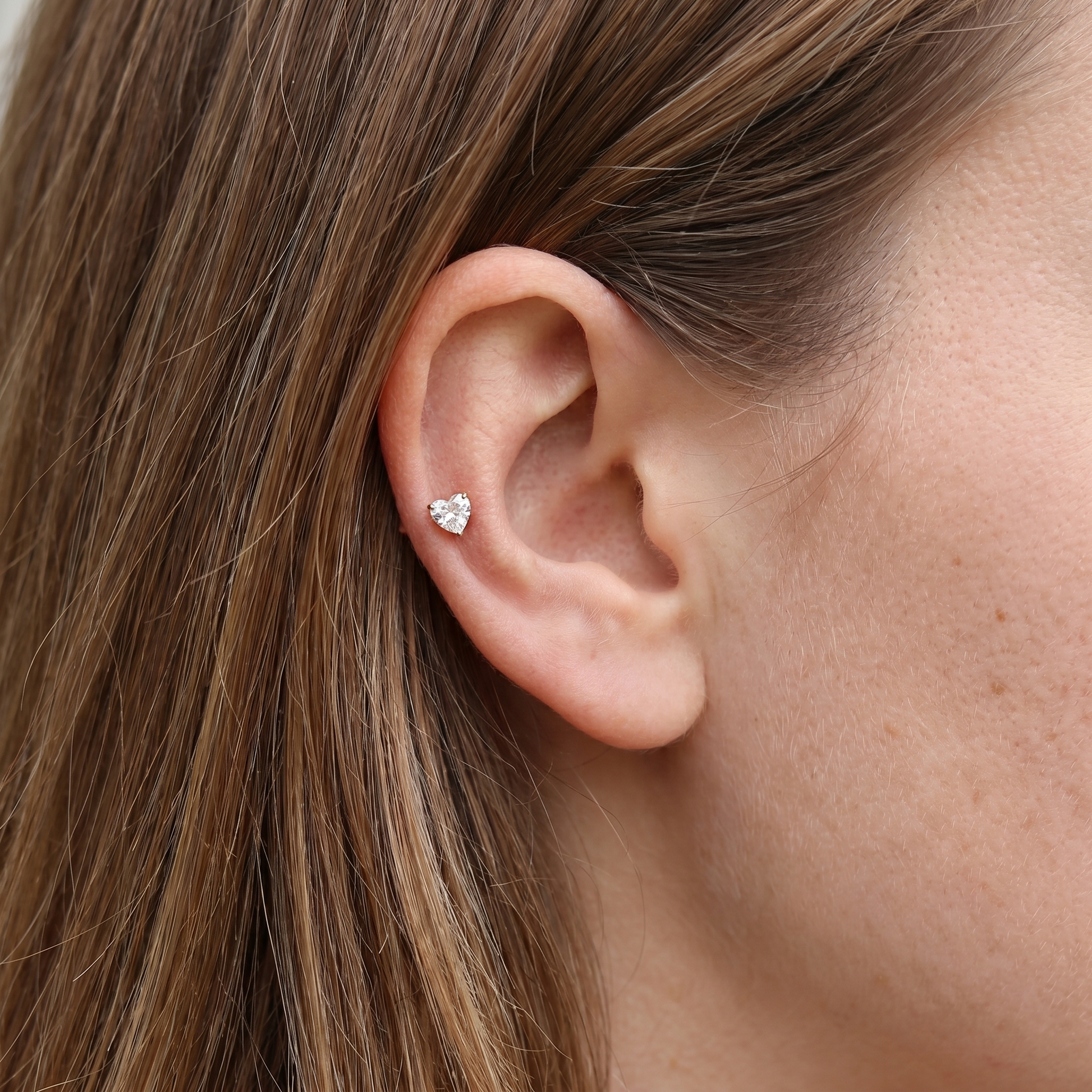 Gold heart zircon stud — mid helix piercing placement