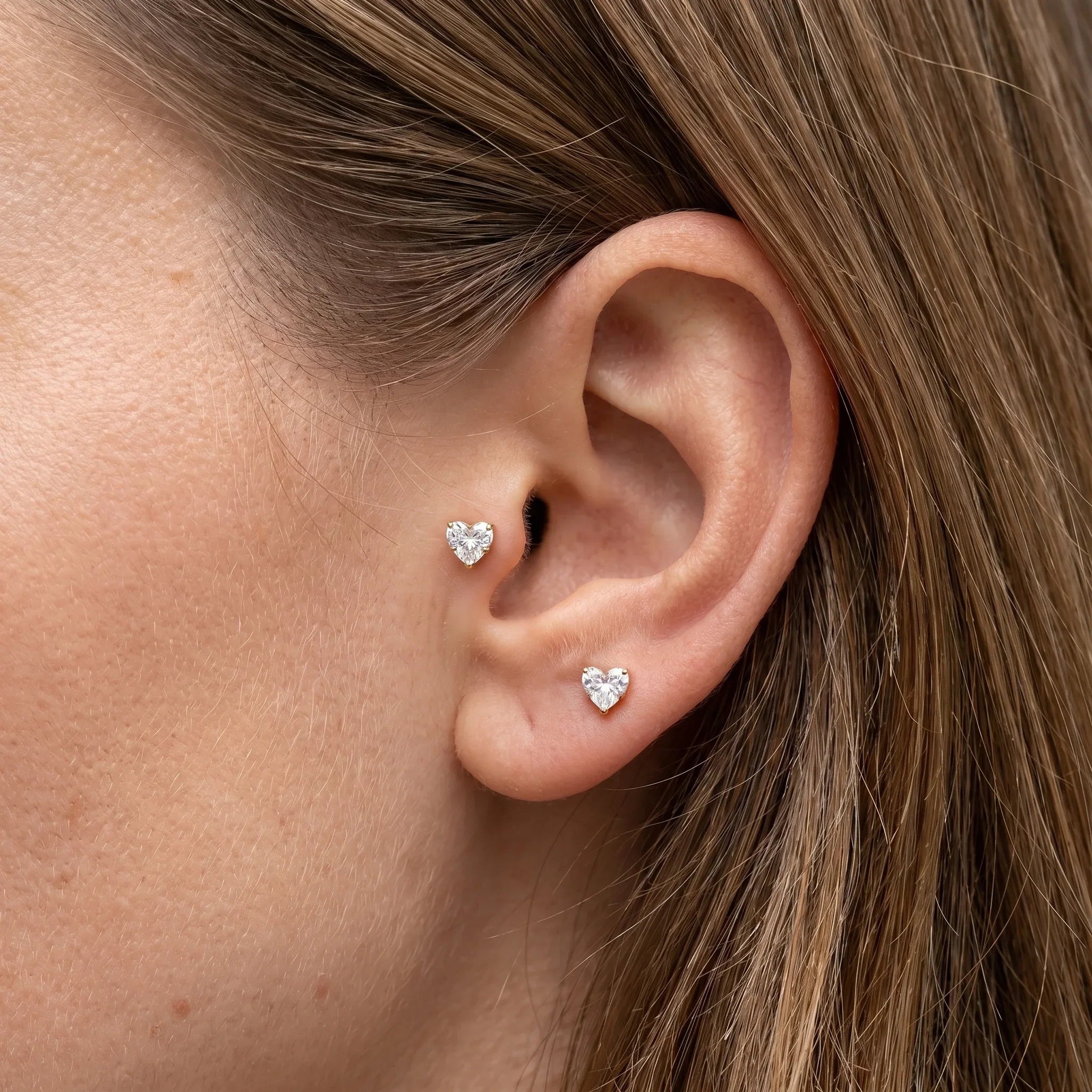 Gold heart zircon stud — piercing placement