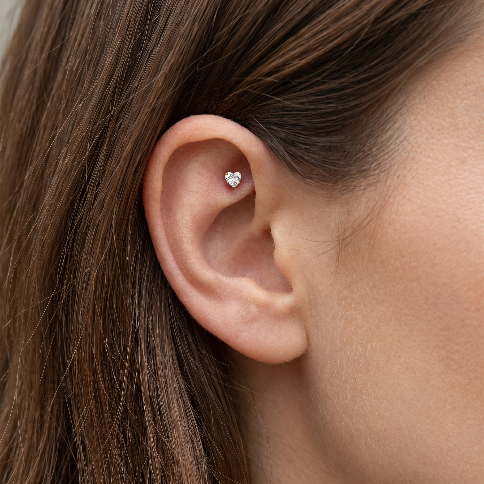 Gold heart zircon stud — piercing placement