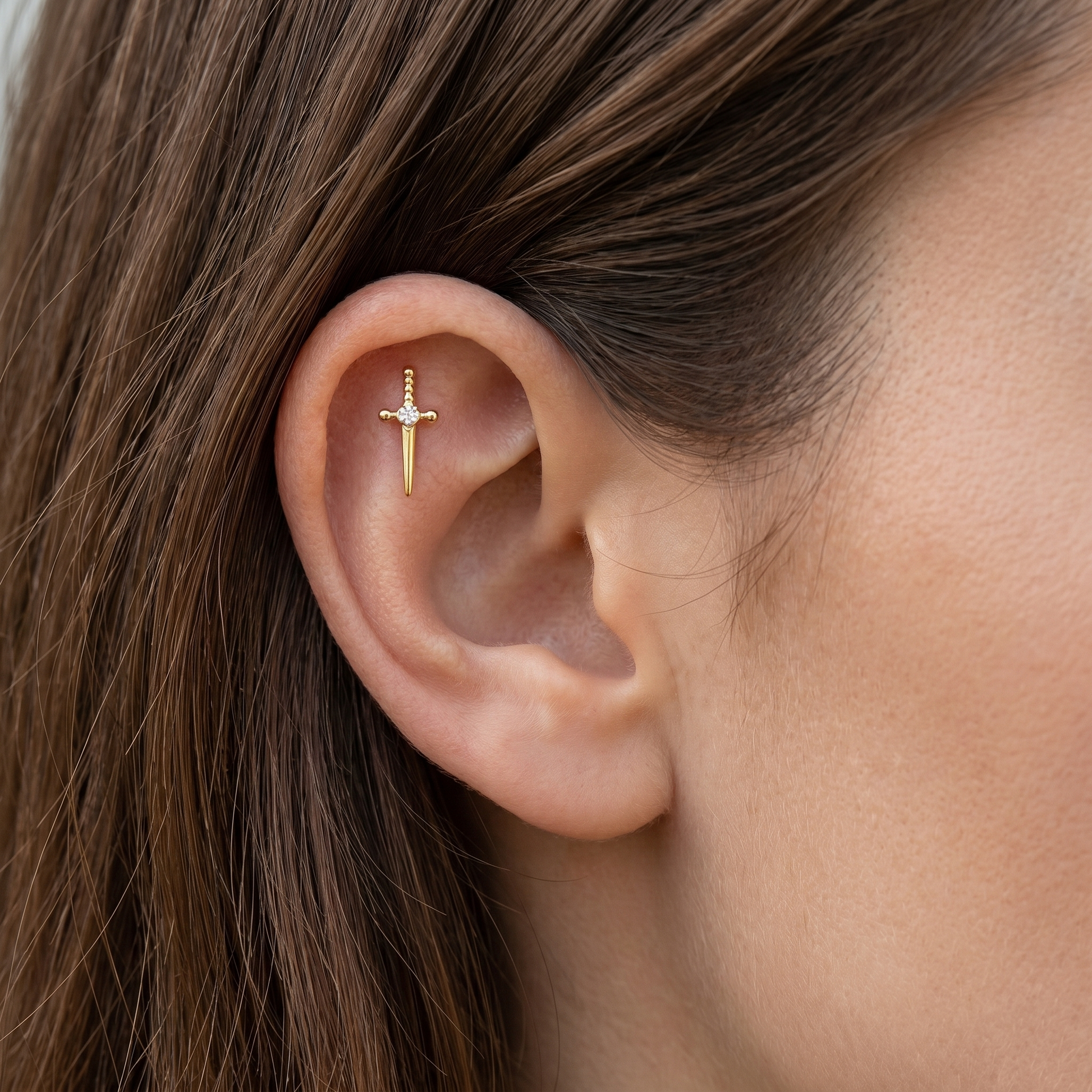 Gold dagger zircon stud — flat helix piercing placement