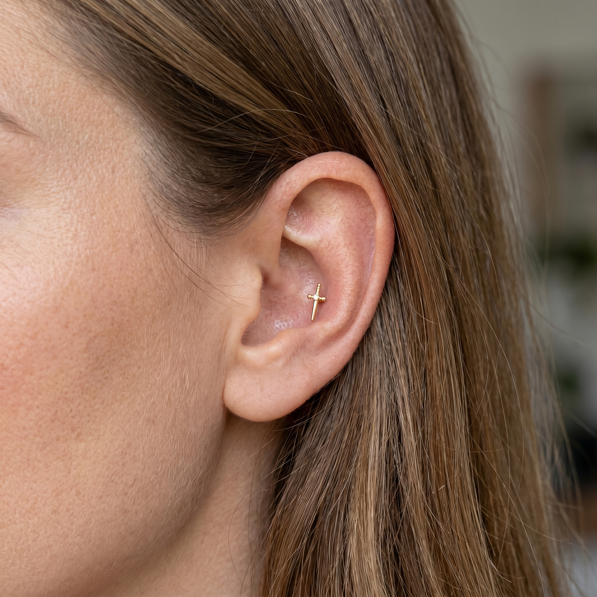 Gold dagger zircon stud — outer conch piercing placement
