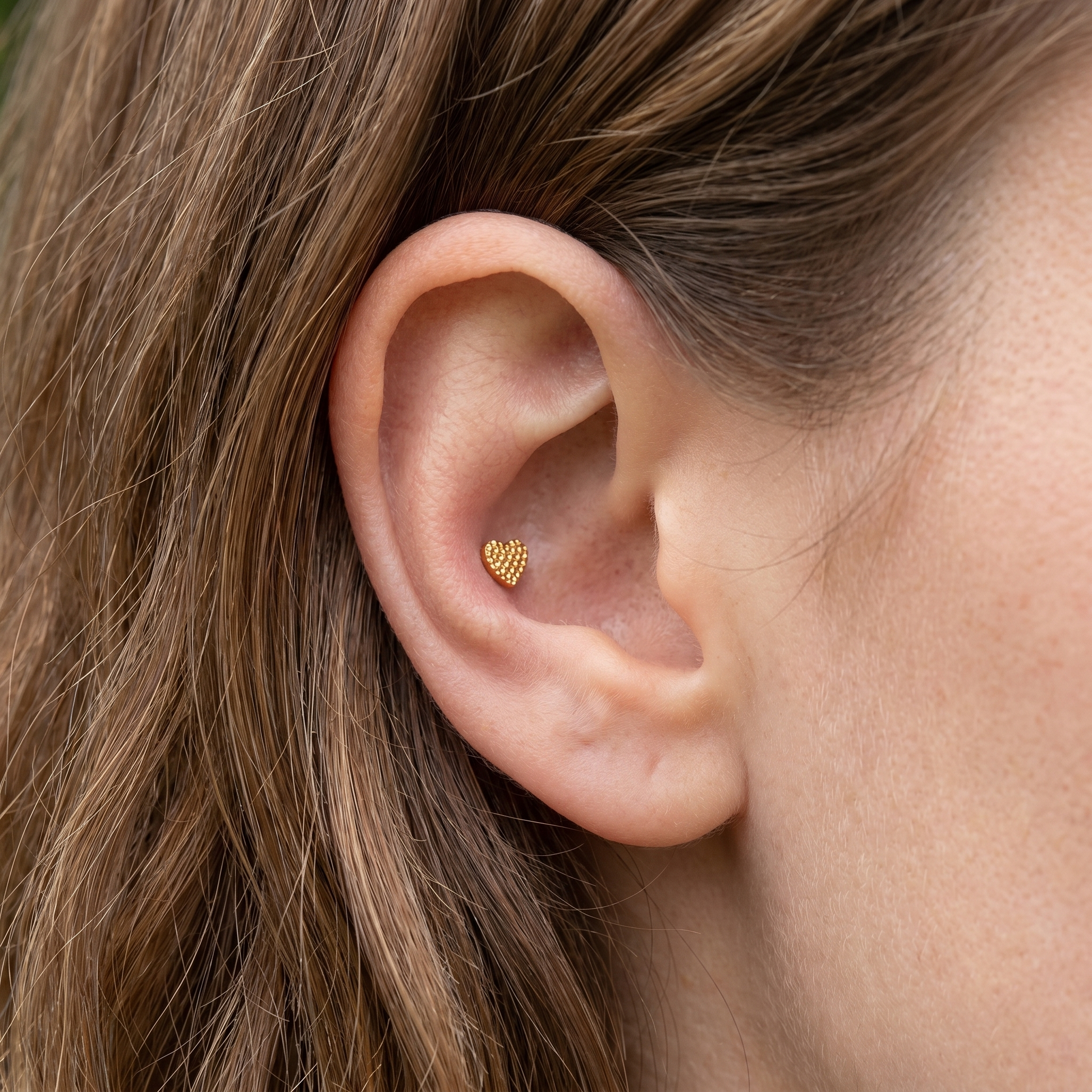Gold textured heart stud — outer conch piercing placement