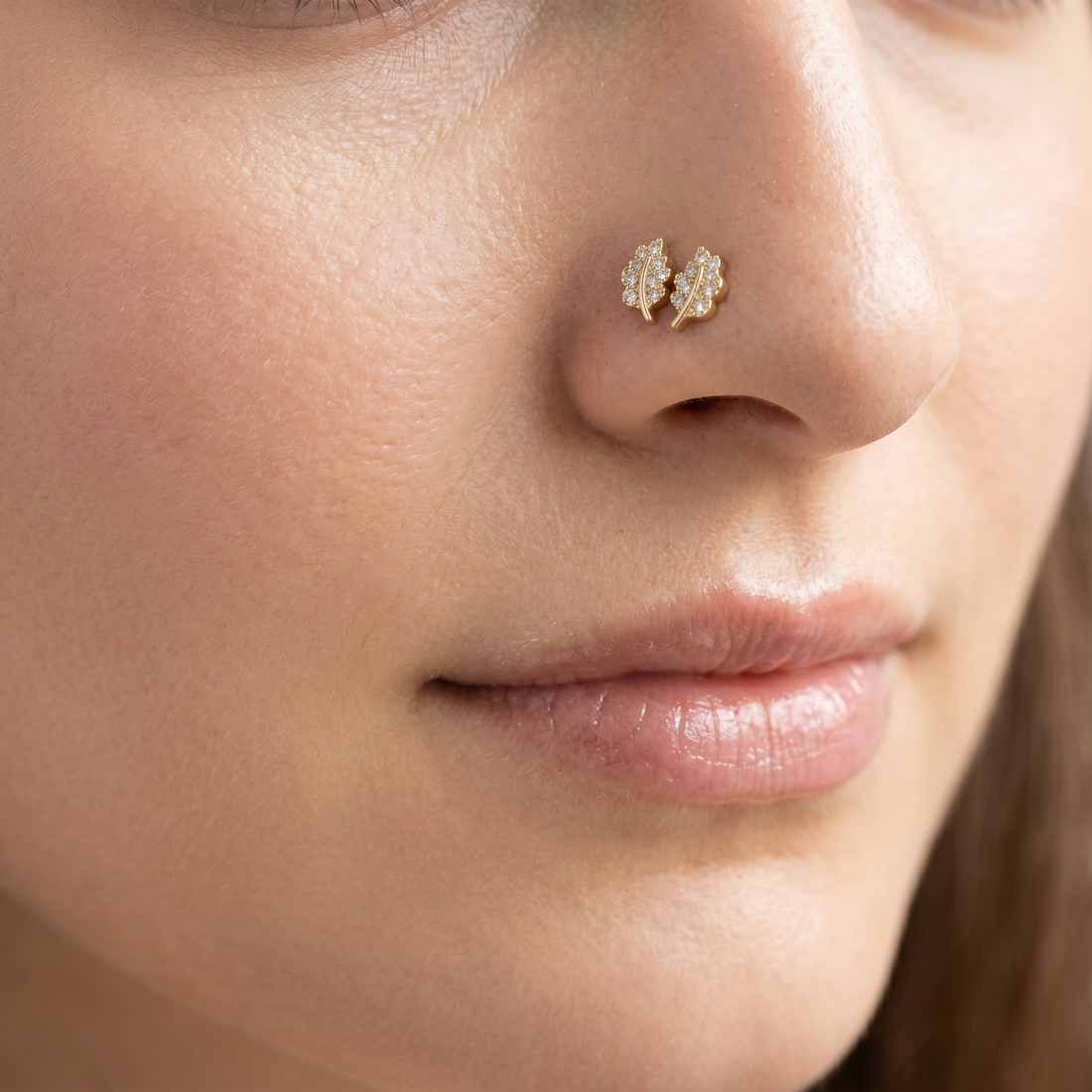 Two leaf nose studs styled as a double nose piercing on one nostril