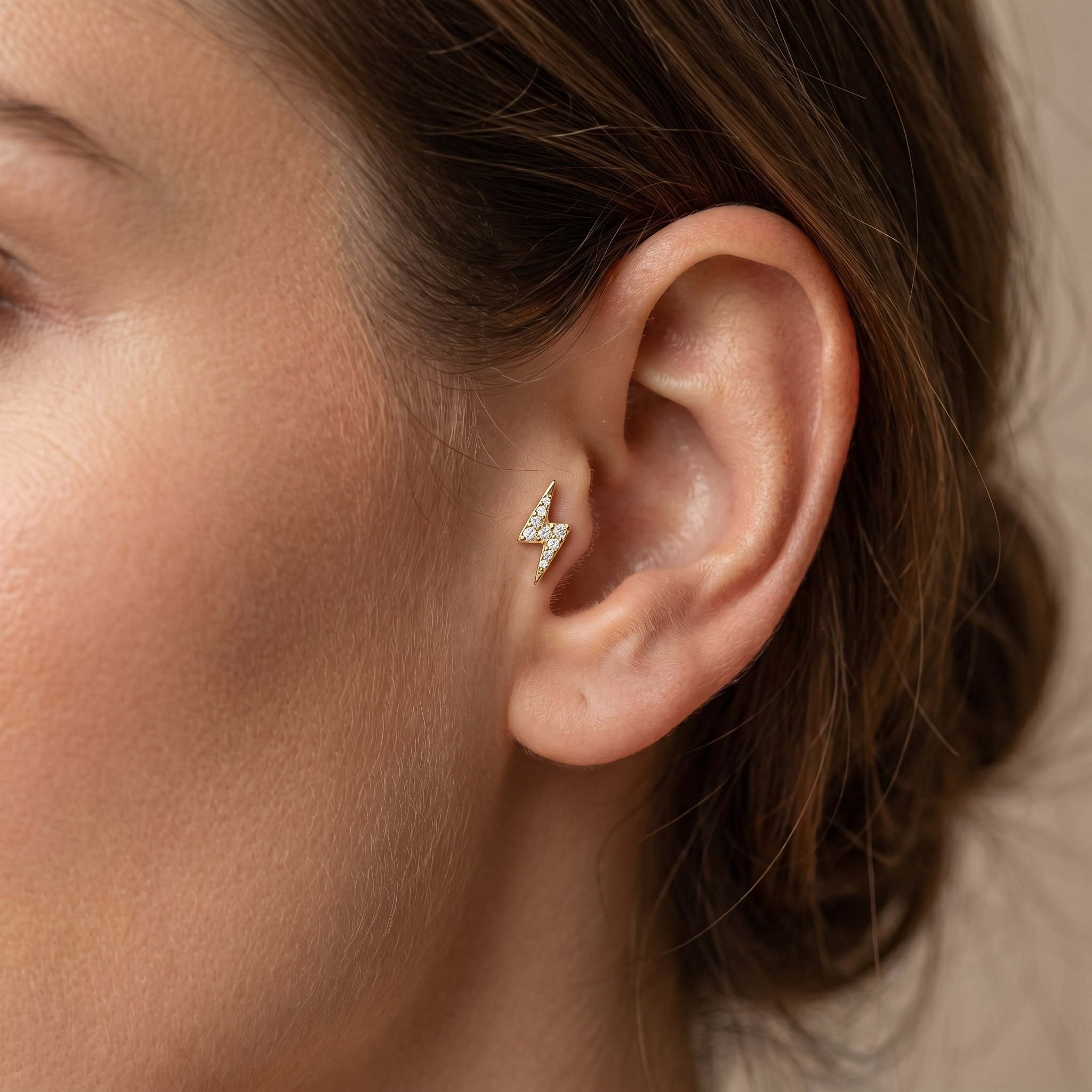 Gold lightning bolt piercing jewelry in a 16G.
