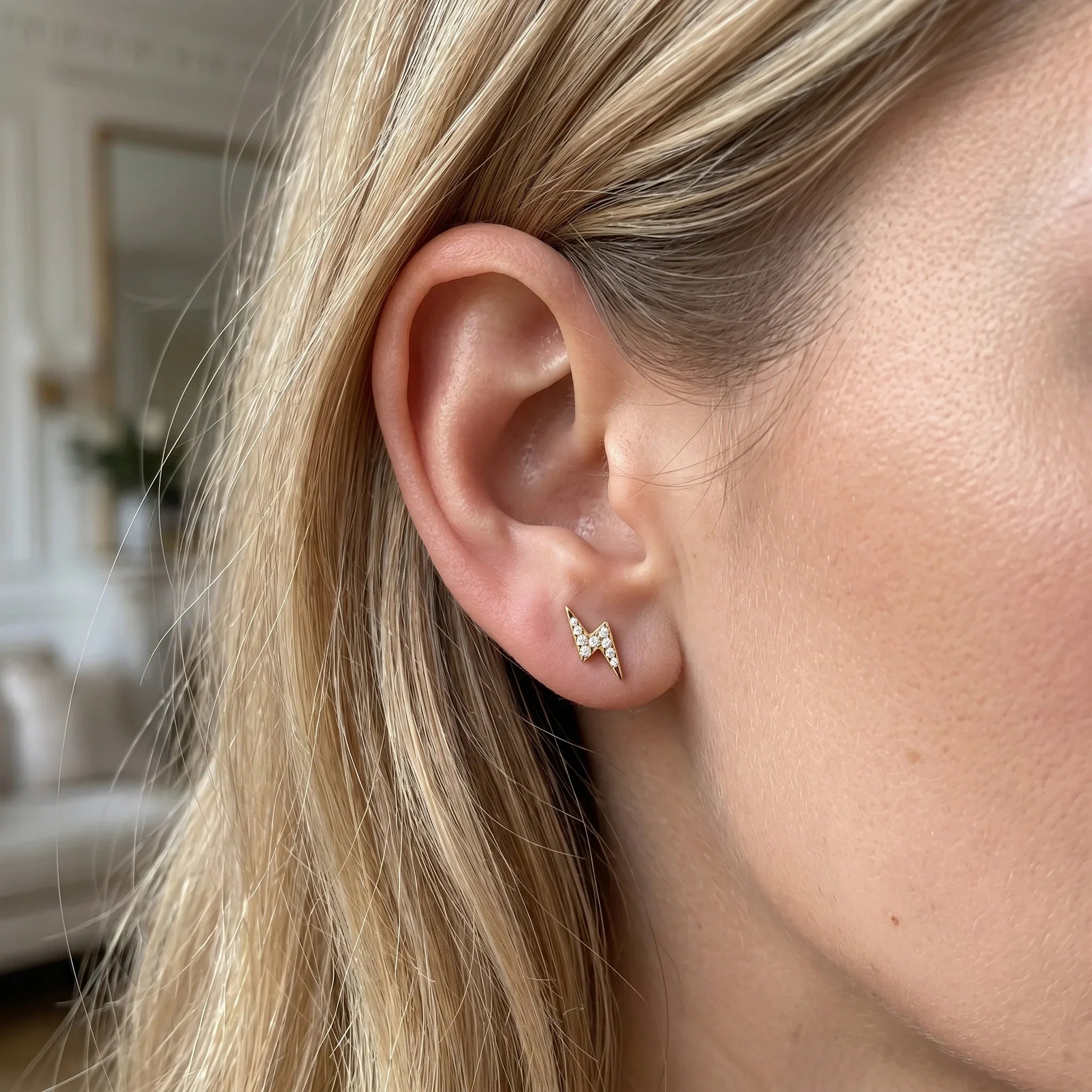 Gold lightning bolt piercing jewelry in a 16G ear cartilage stack.
