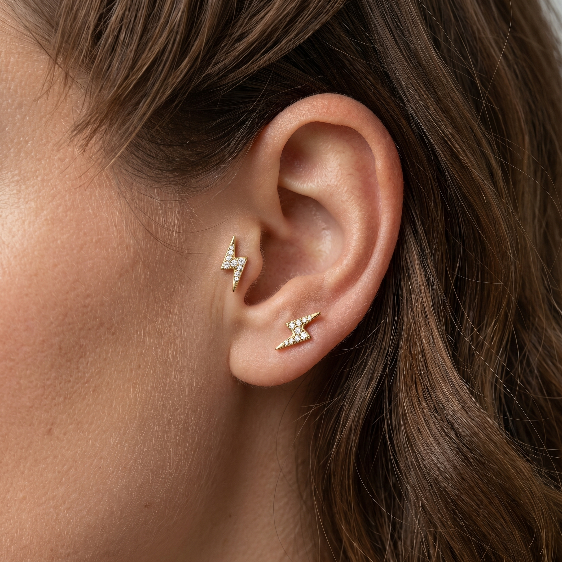 Gold lightning bolt and piercings jewelry in a 16G.