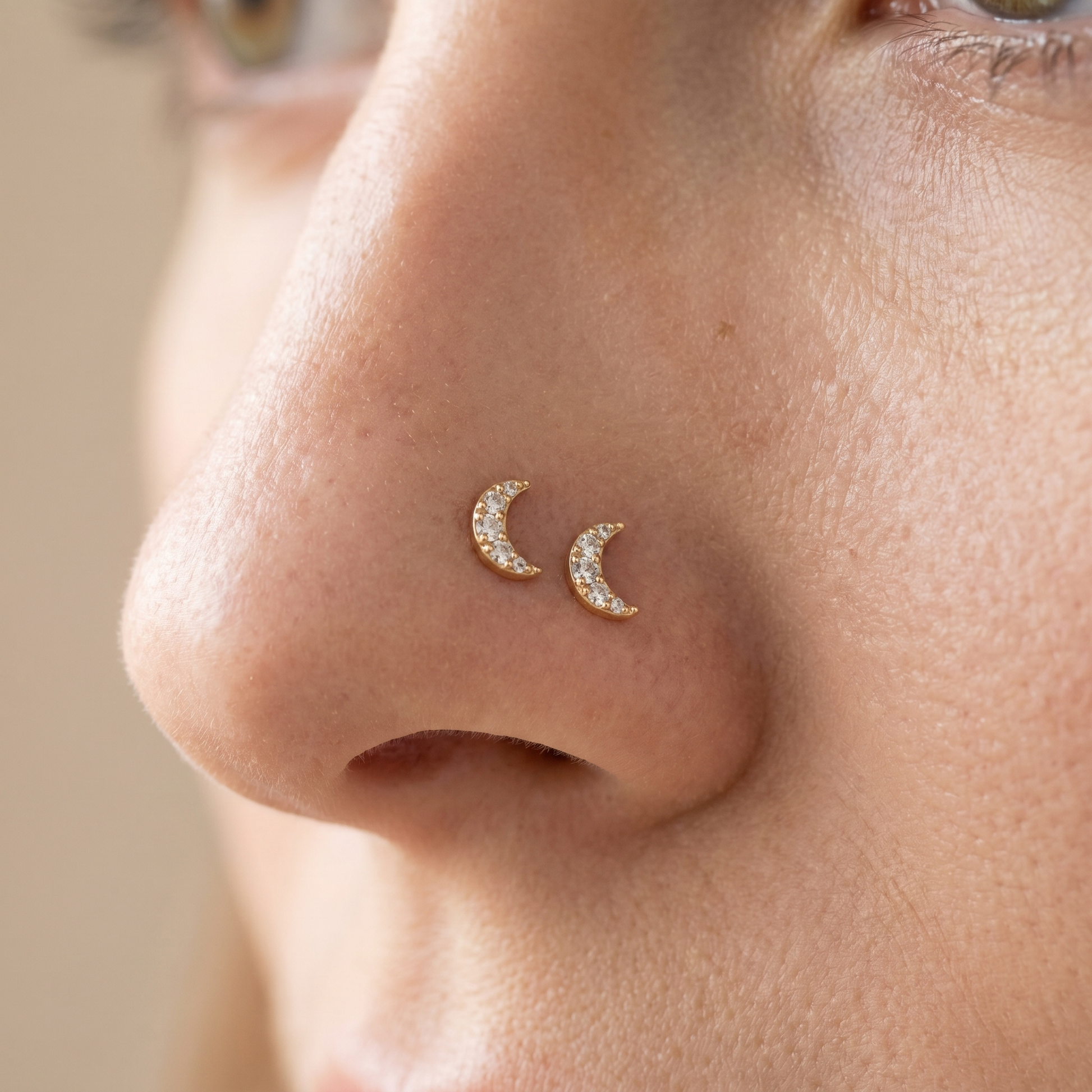Two moon nose studs styled as a double nose piercing on one nostril