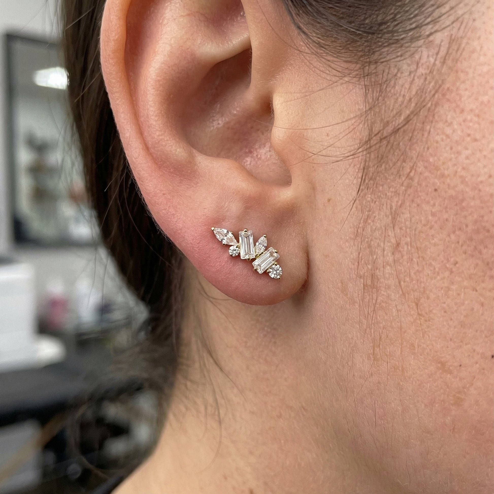 Model showcasing a silver multi-stone zircon cluster in a standard lower piercing.