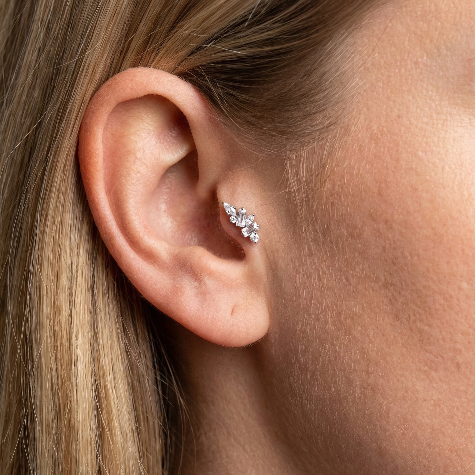 Model displaying a silver titanium zircon cluster styled elegantly in a cartilage