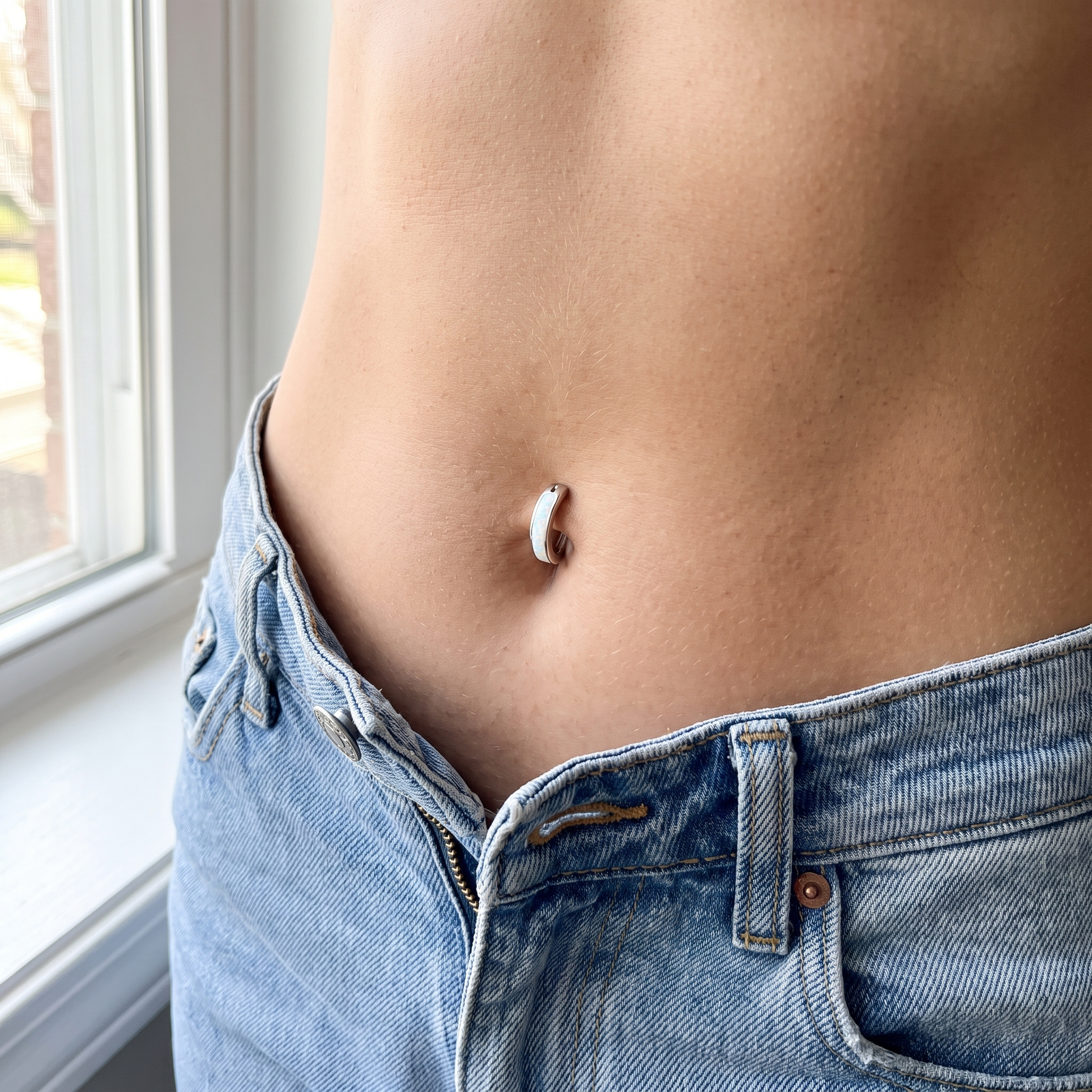 Opal belly button ring in white opal worn on model — implant-grade G23 titanium 14G